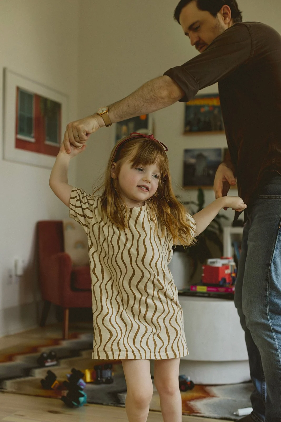 New Orleans in-home family photographer documenting father and daughter dancing in living room.