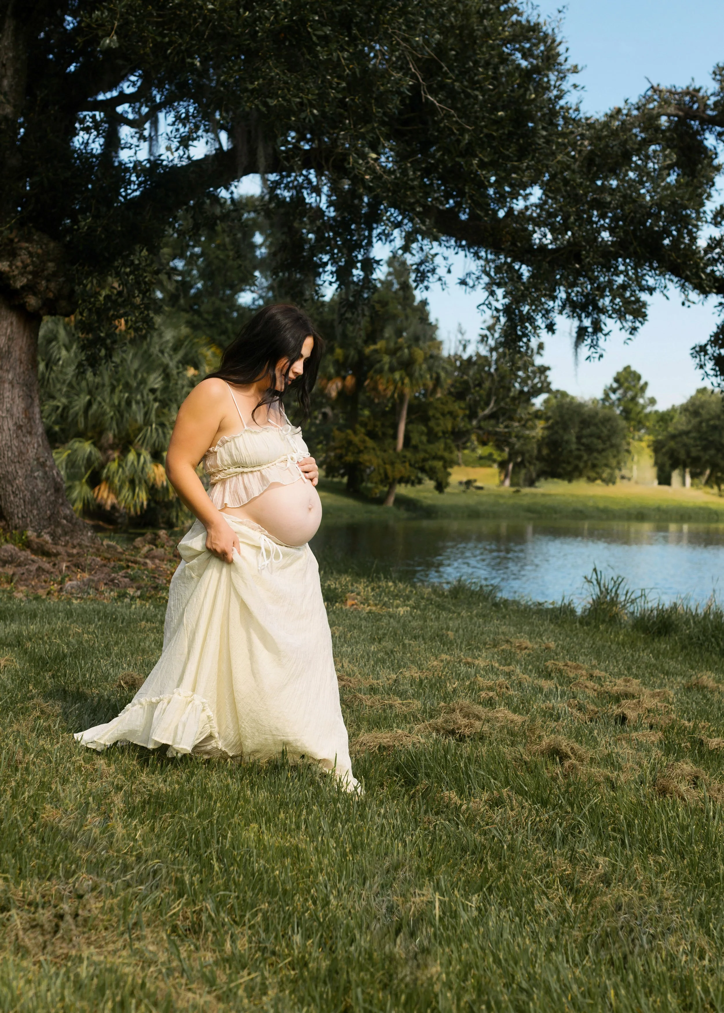 Maternity photography in New Orleans City Park, mom in flowing dress surrounded by greenery.