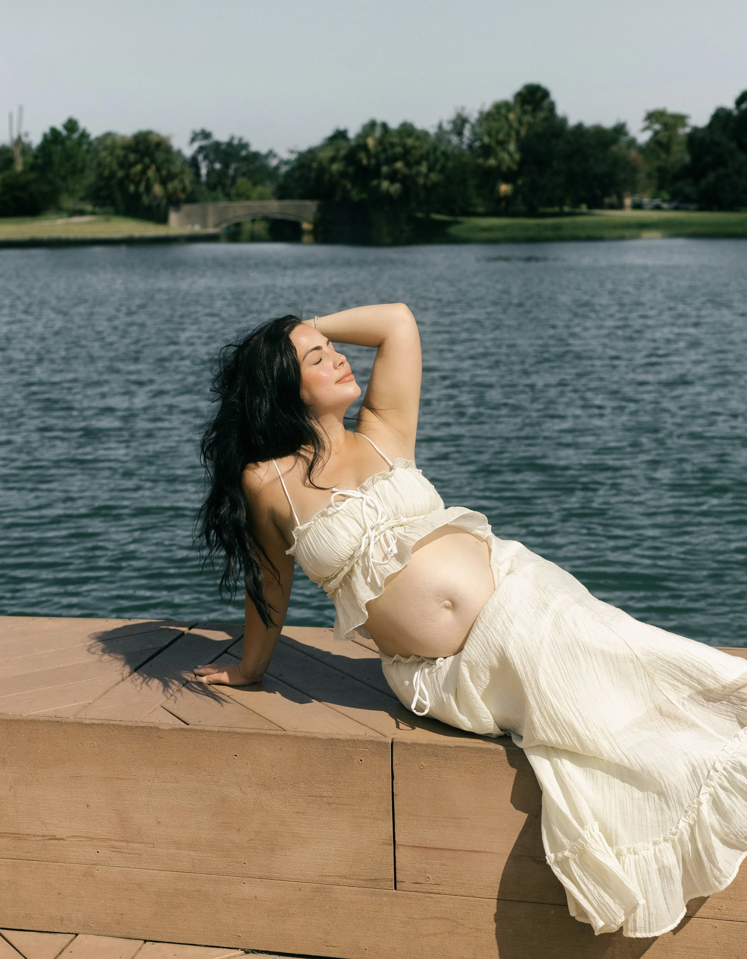 Joyful maternity portrait in City Park New Orleans, mom-to-be smiling in soft natural light.