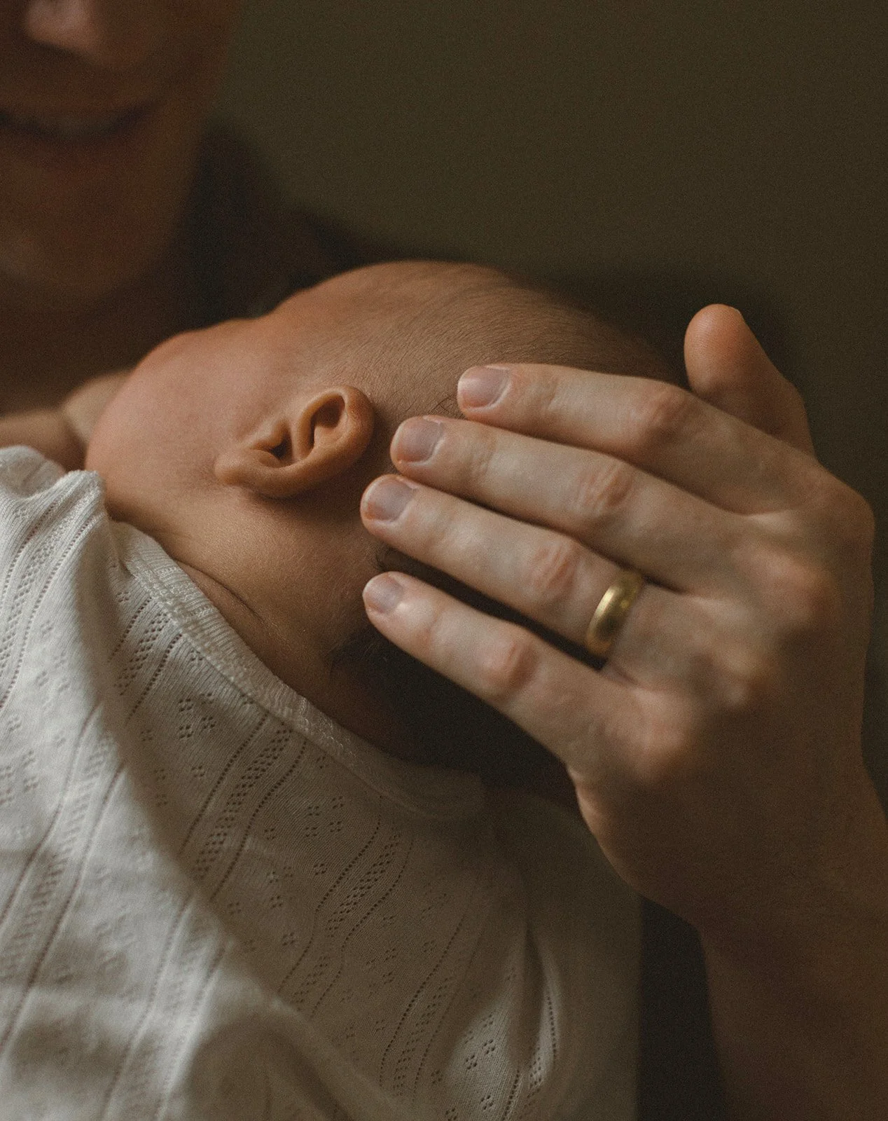 Father gently holding his newborn baby during a relaxed lifestyle newborn session in New Orleans.