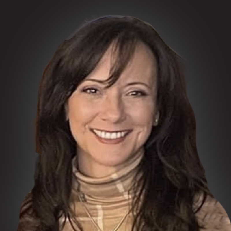 A woman with shoulder-length brown hair smiling, wearing a beige plaid turtleneck sweater.