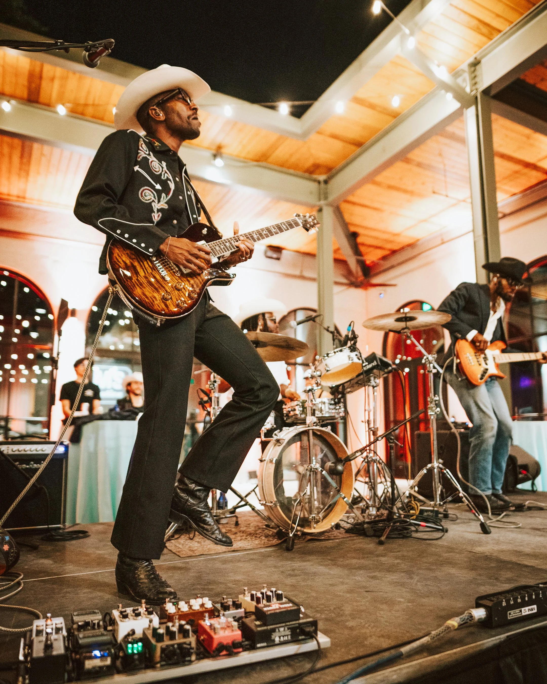 A guitarist and the band performing for a SIMS non profit event in Austin Texas.