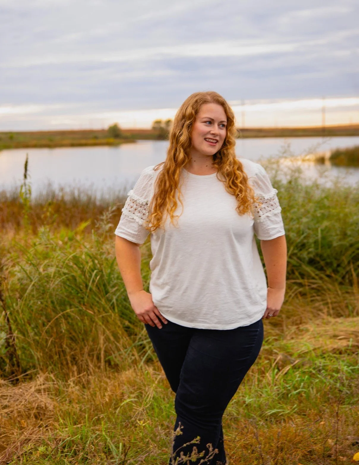 Natasha Bradt, Founder of 3 Lakes Bookkeeping, smiling in an outdoor portrait next to a peaceful lake landscape, representing clarity and care in small business accounting.