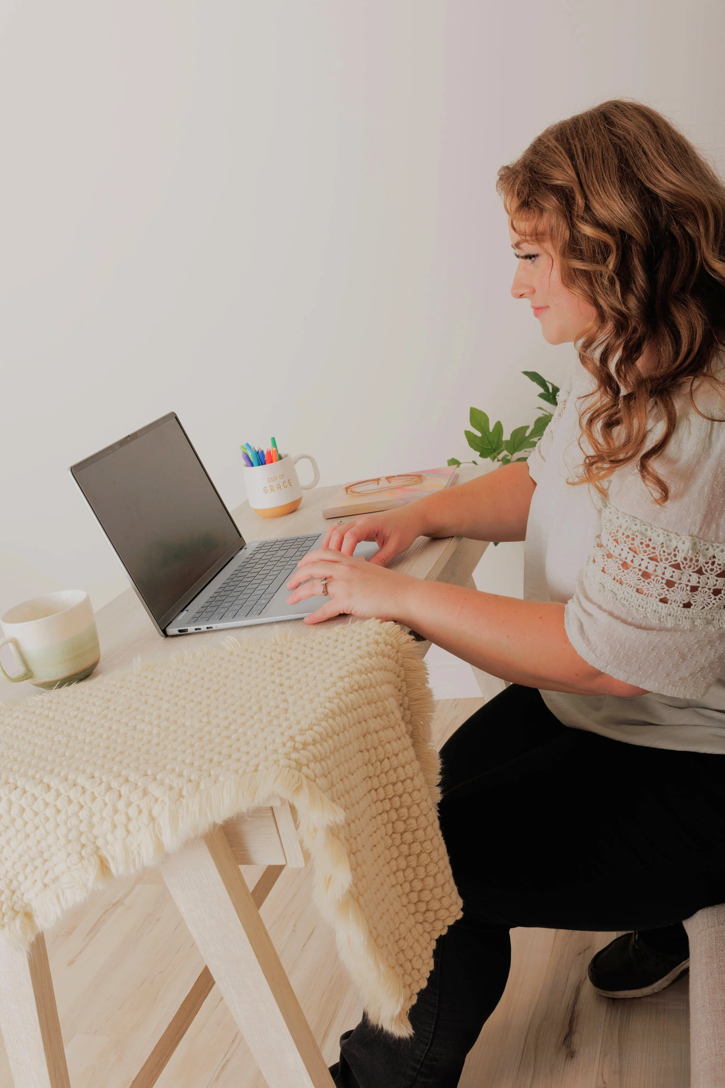 Natasha Bradt, Founder of 3 Lakes Bookkeeping, typing on a laptop at her desk, providing outsourced monthly bookkeeping, payroll management, and QuickBooks Online setup services.