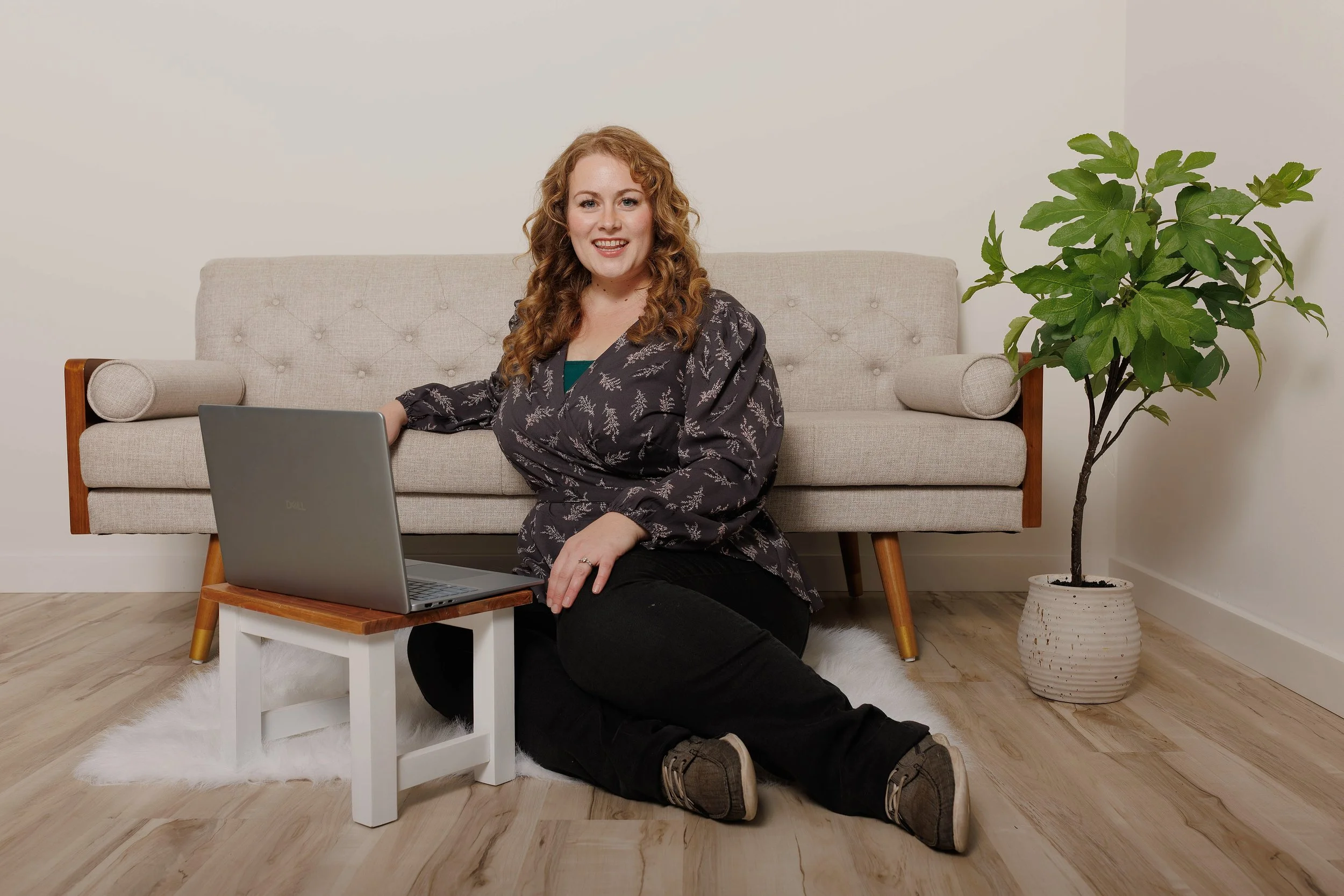 Natasha Bradt, Founder of 3 Lakes Bookkeeping, smiling and approachable while working on a laptop in a modern setting, offering remote monthly bookkeeping and financial advisory services for small businesses.