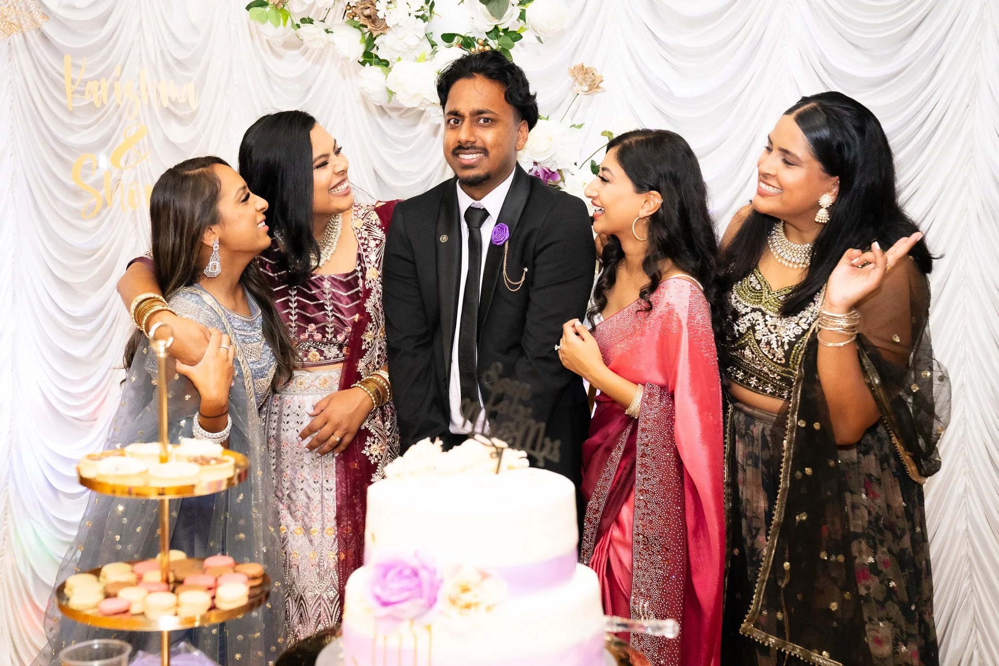 Bridal party group photo with floral backdrop and dessert table - Sydney event photography.