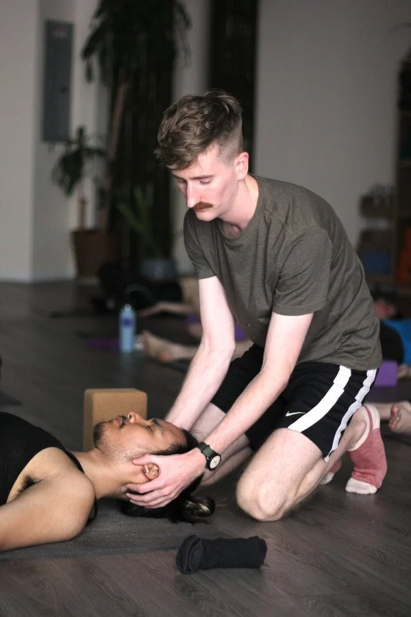 Private yoga instructor Jimmie Costello performing a hands-on Thai bodywork massage during a one-on-one session.