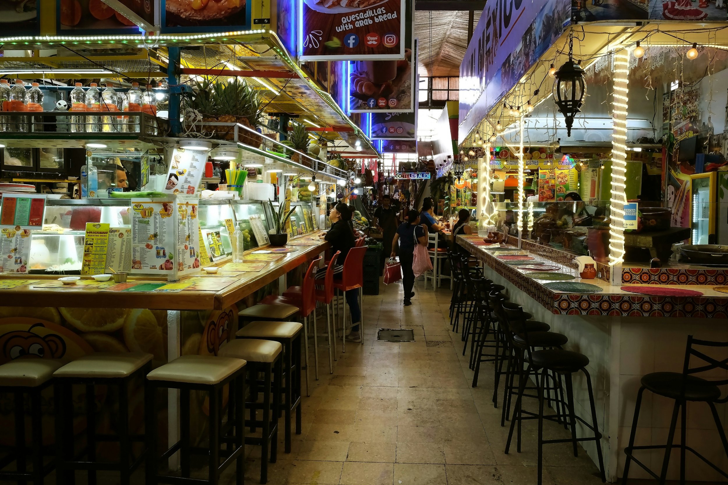 Vibrant indoor marketplace with food stalls and seating