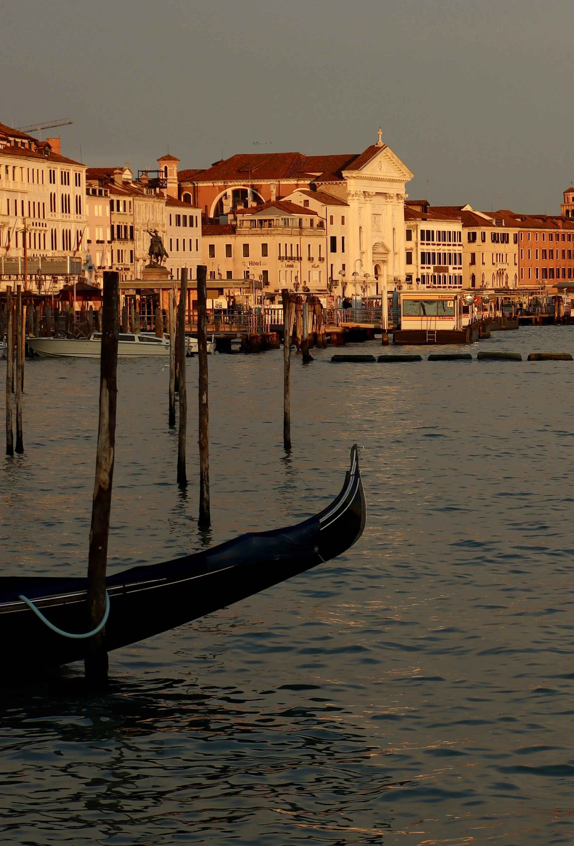 Venice canal at sunset with gondola and historic buildings