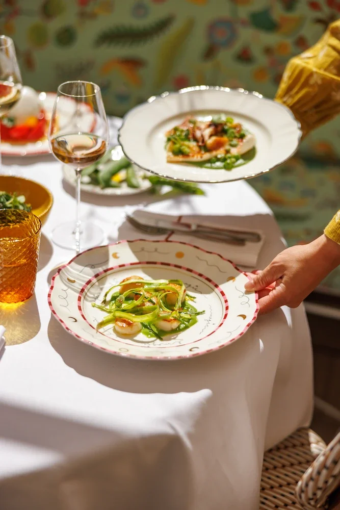 Luxurious bathroom with marble walls and floor, wooden vanity, glass shower, and bathtub.