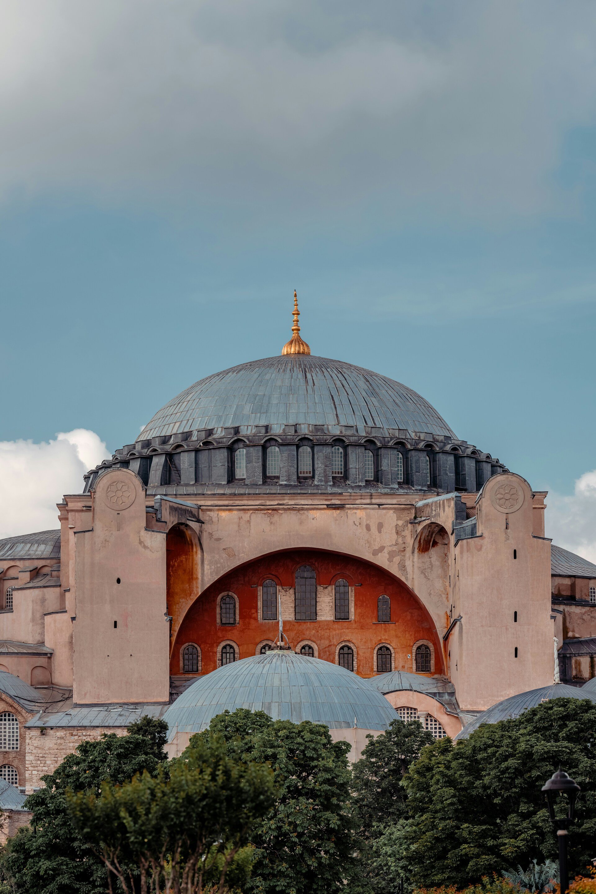 The Hagia Sophia, a historic domed building with a large central dome, surrounded by smaller domes and greenery at the bottom.