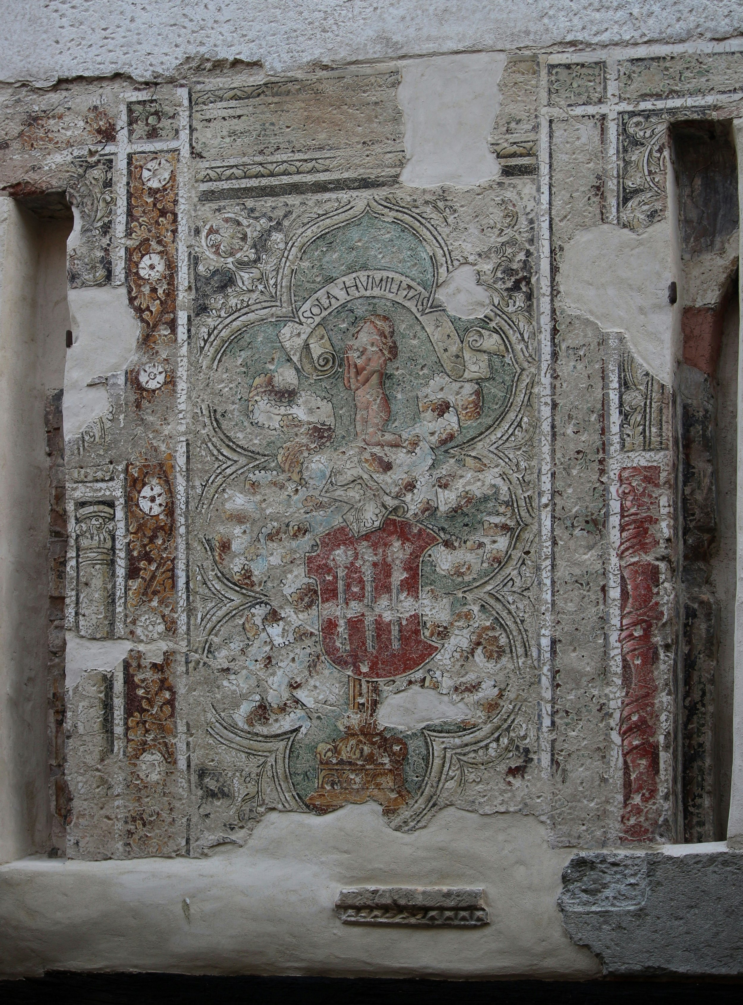 A wall painting depicting a man and woman standing together, showcasing their expressions and attire in vibrant colors.