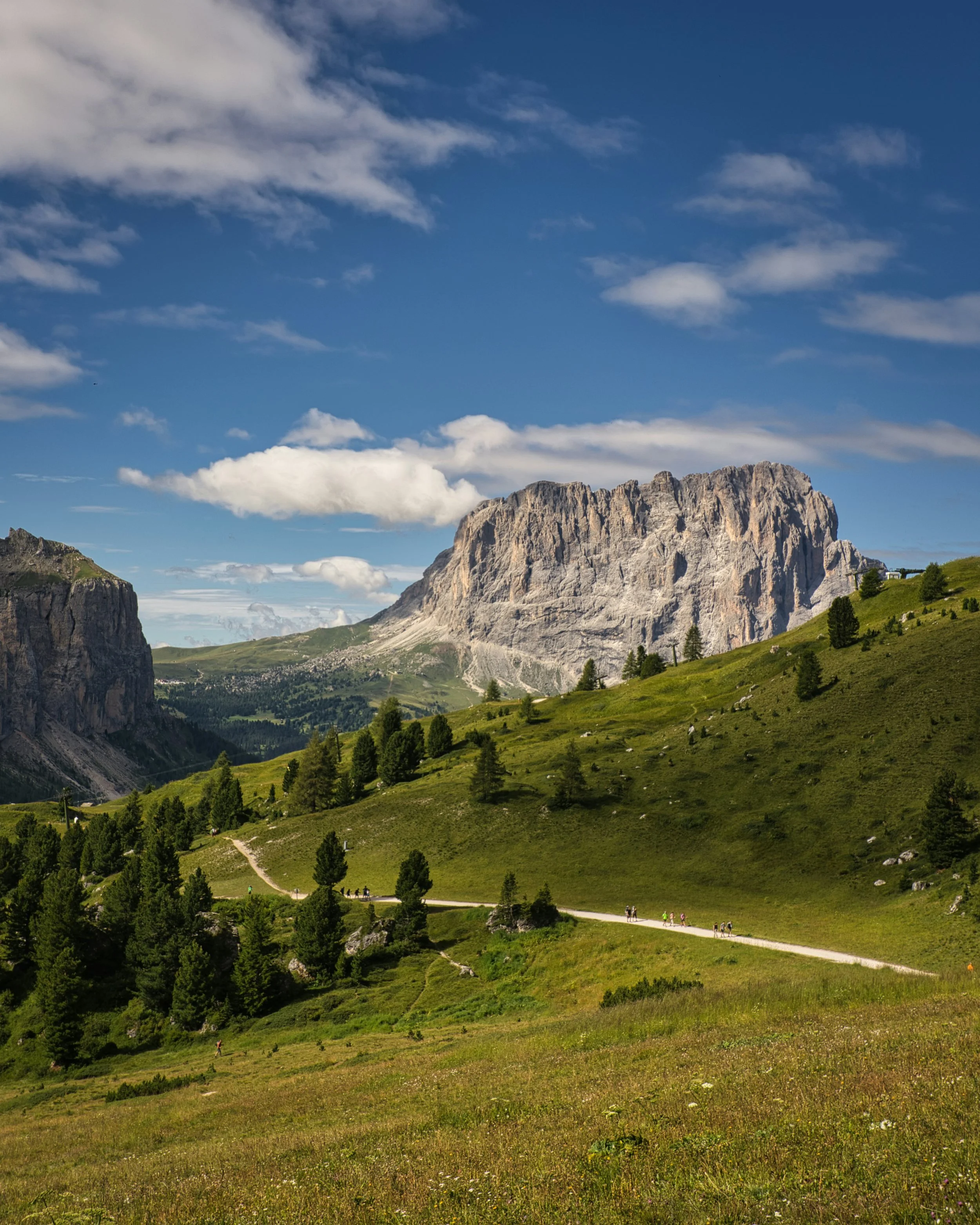 Majestic Dolomites in Italy, showcasing towering peaks and lush valleys under a clear blue sky.