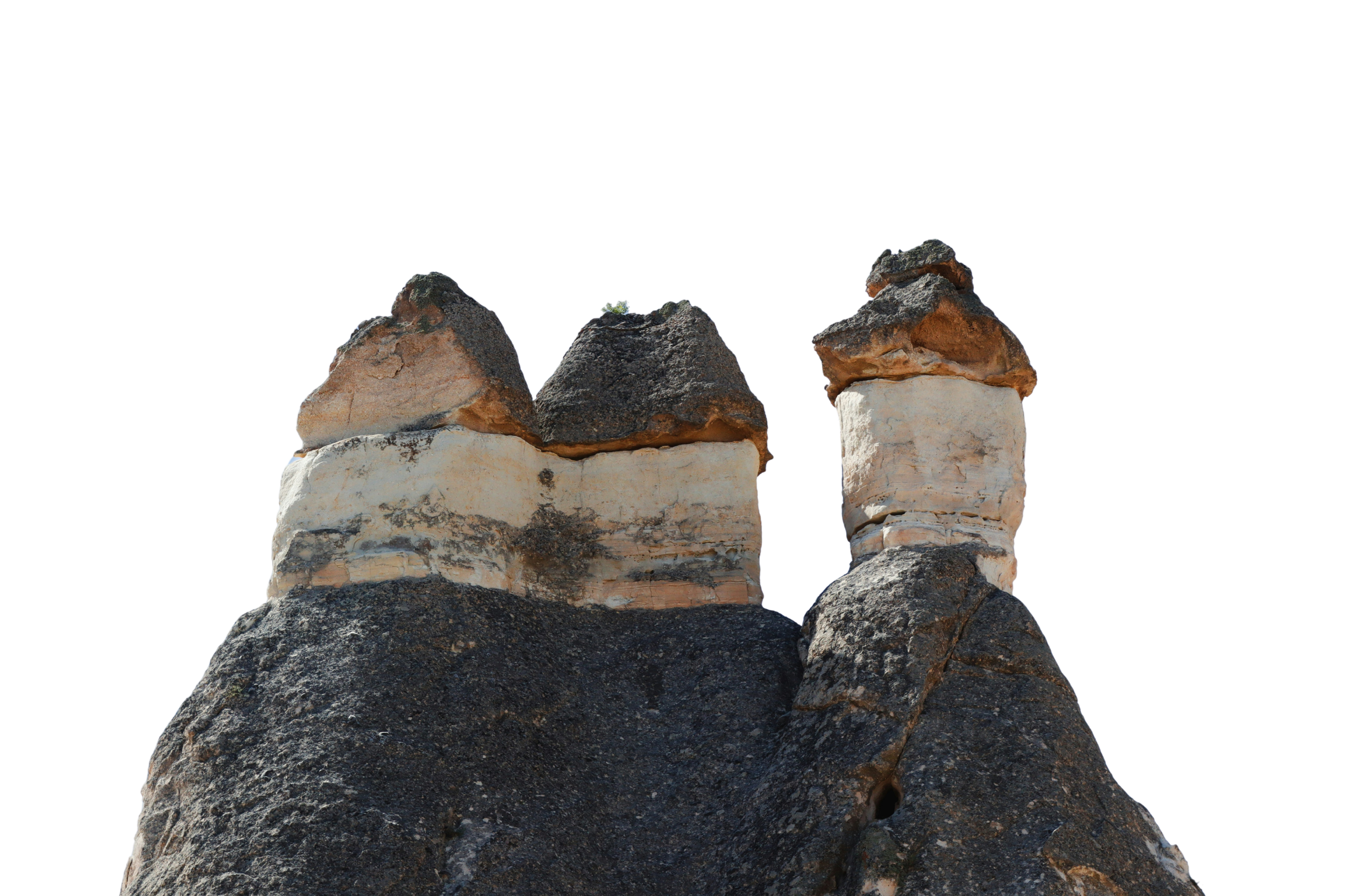 Three large volcanic rocks on a dark, textured rock surface against a black background.