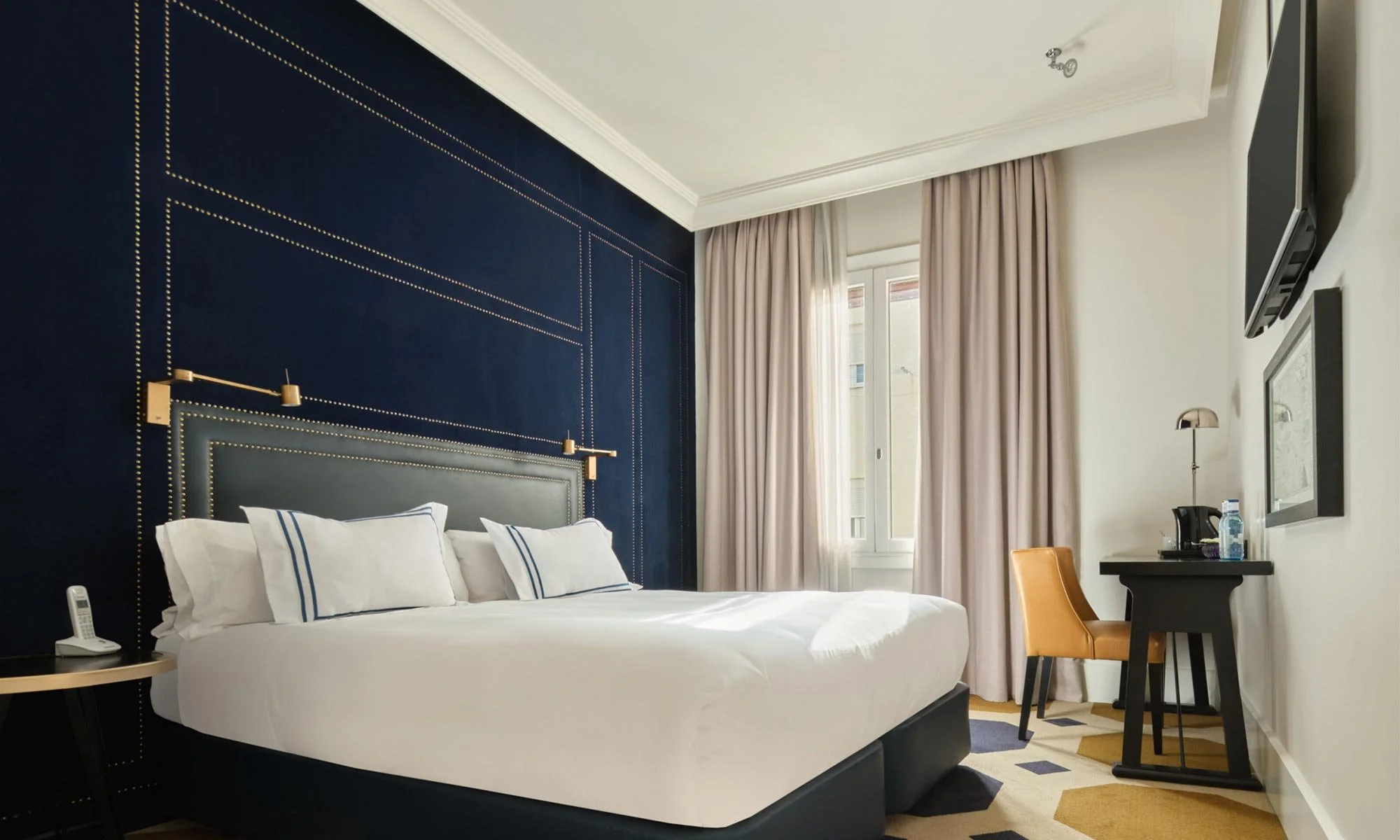 Rooftop restaurant with tables set for dining, overlooking a cityscape featuring historic buildings and domes at sunset.