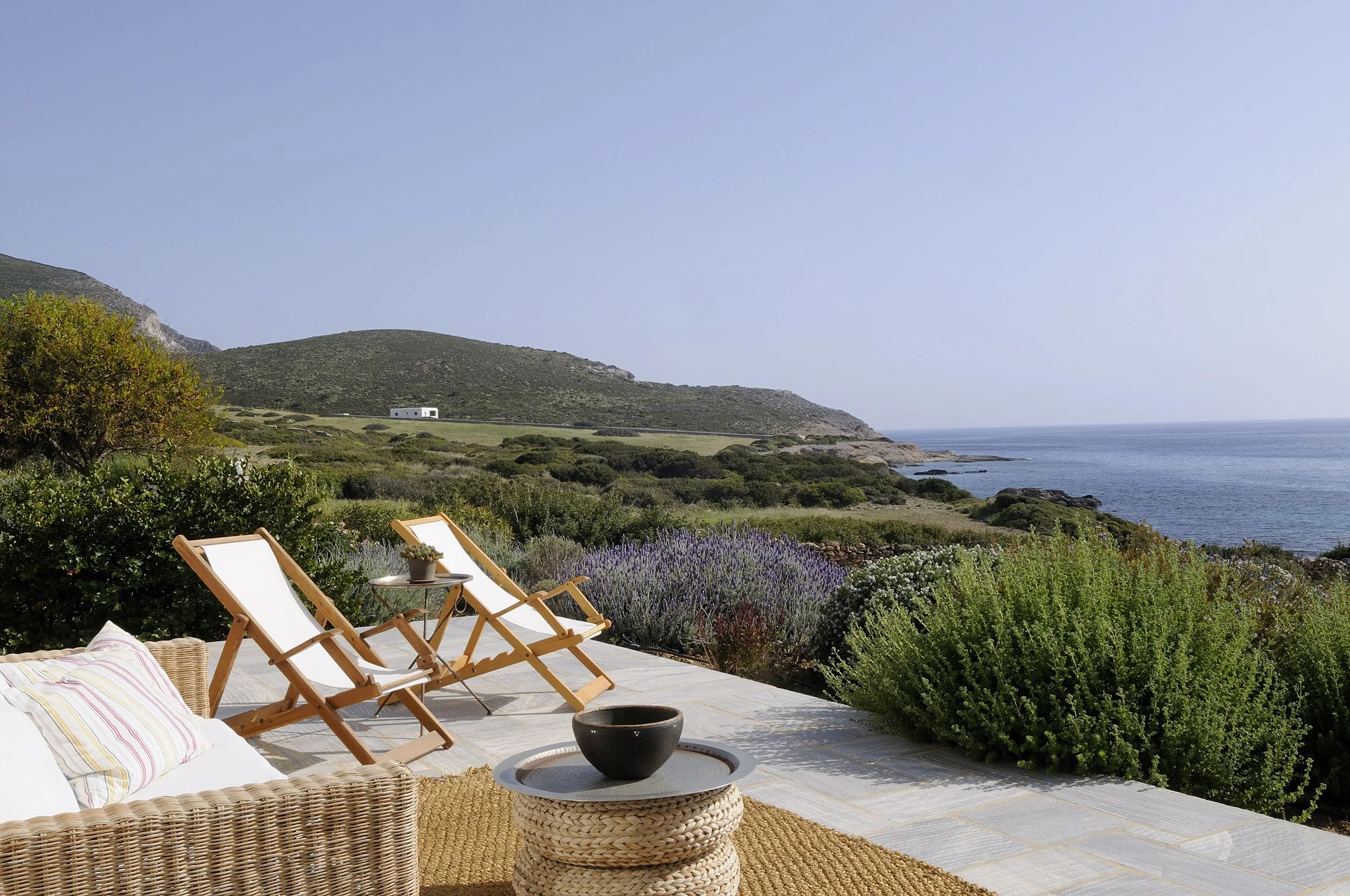 Luxury villa with sea views, lavender plants and deck chairs.