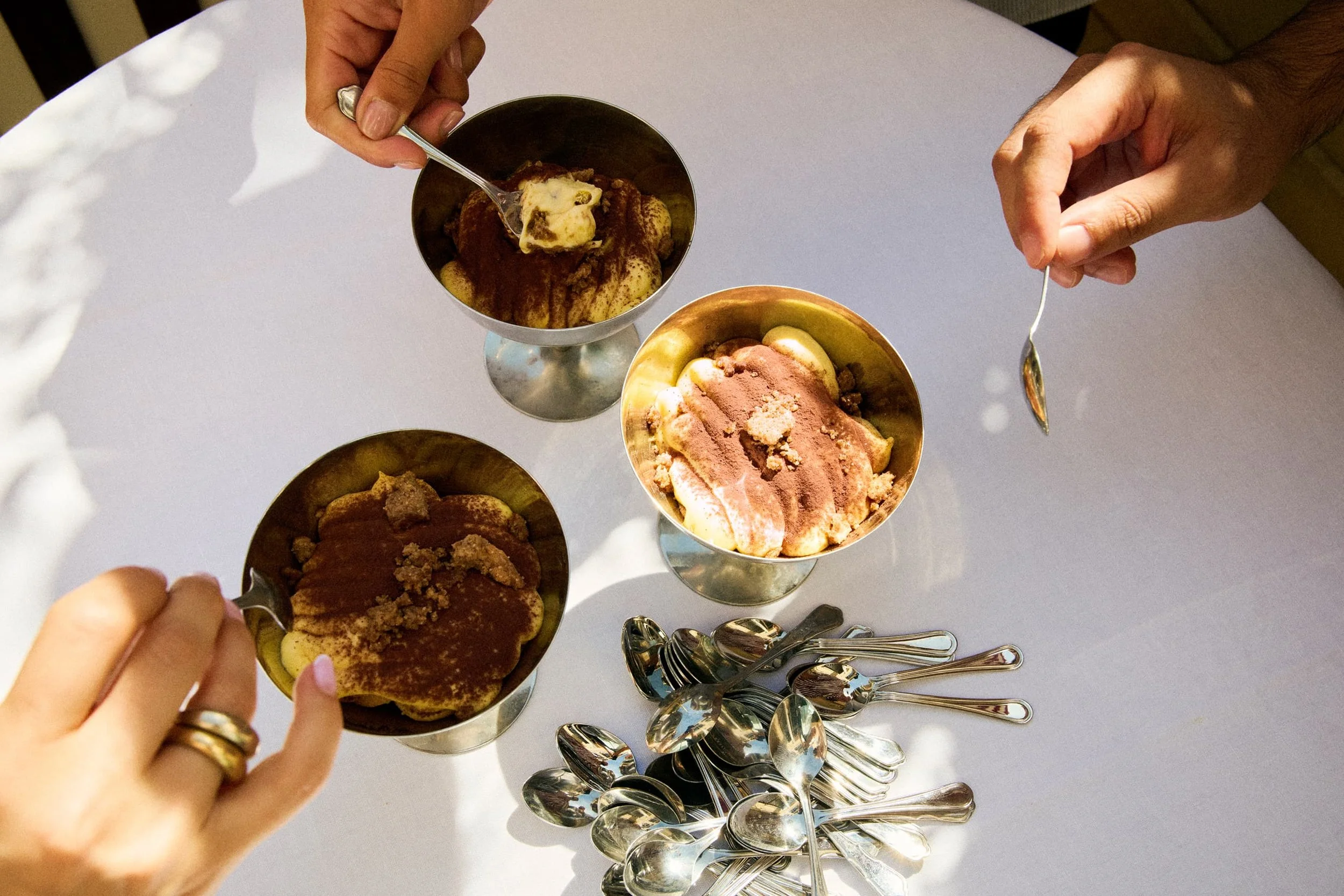 Rooftop restaurant with tables set for dining, overlooking a cityscape featuring historic buildings and domes at sunset.