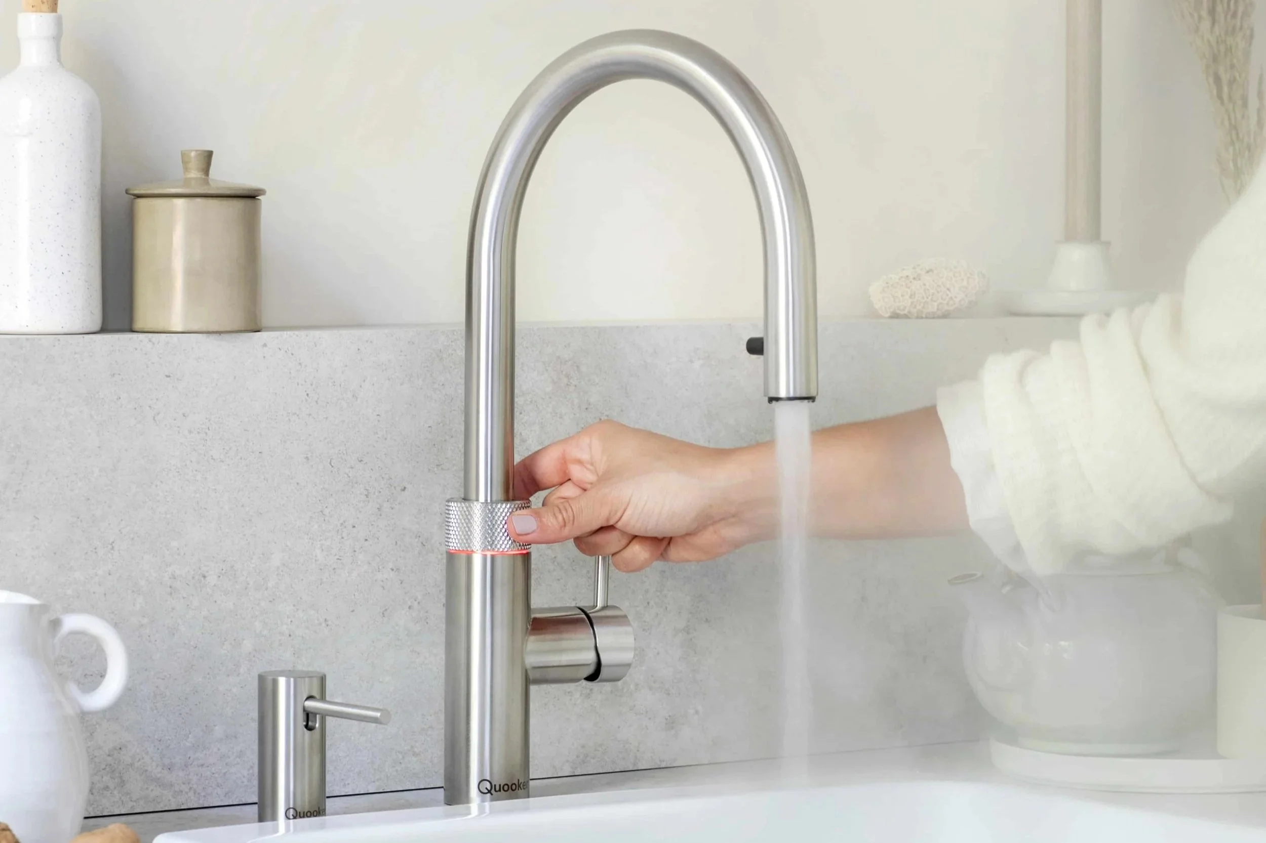 Quooker Flex Armatur in gebürstetem Edelstahl mit kochendem Wasser und dem dazu passenden Seifenspender von Quooker.