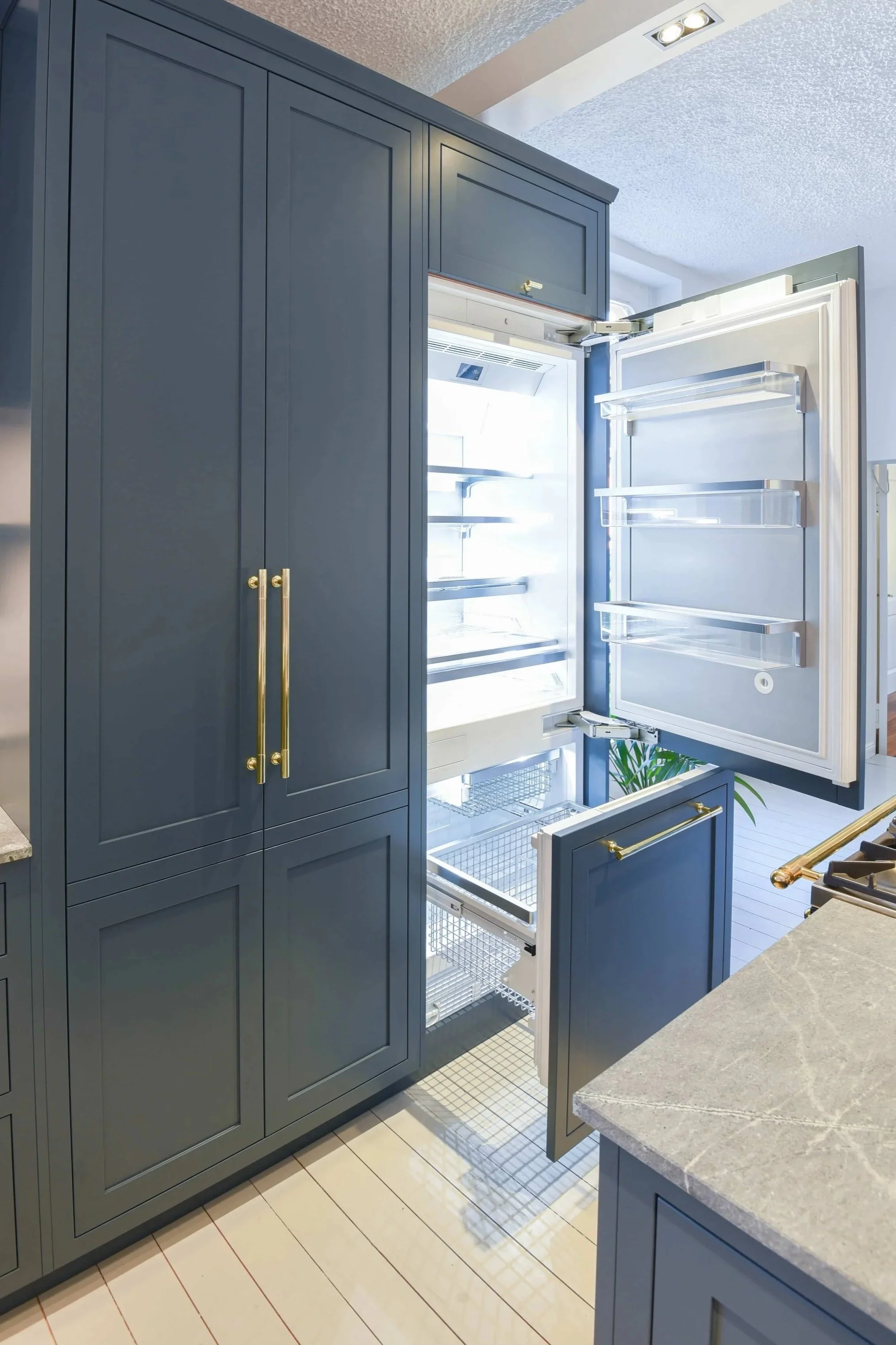 Kühl-Gefrierschrank Miele Mastercool in einer blauen Shaker Kitchen mit Messinggriffen.