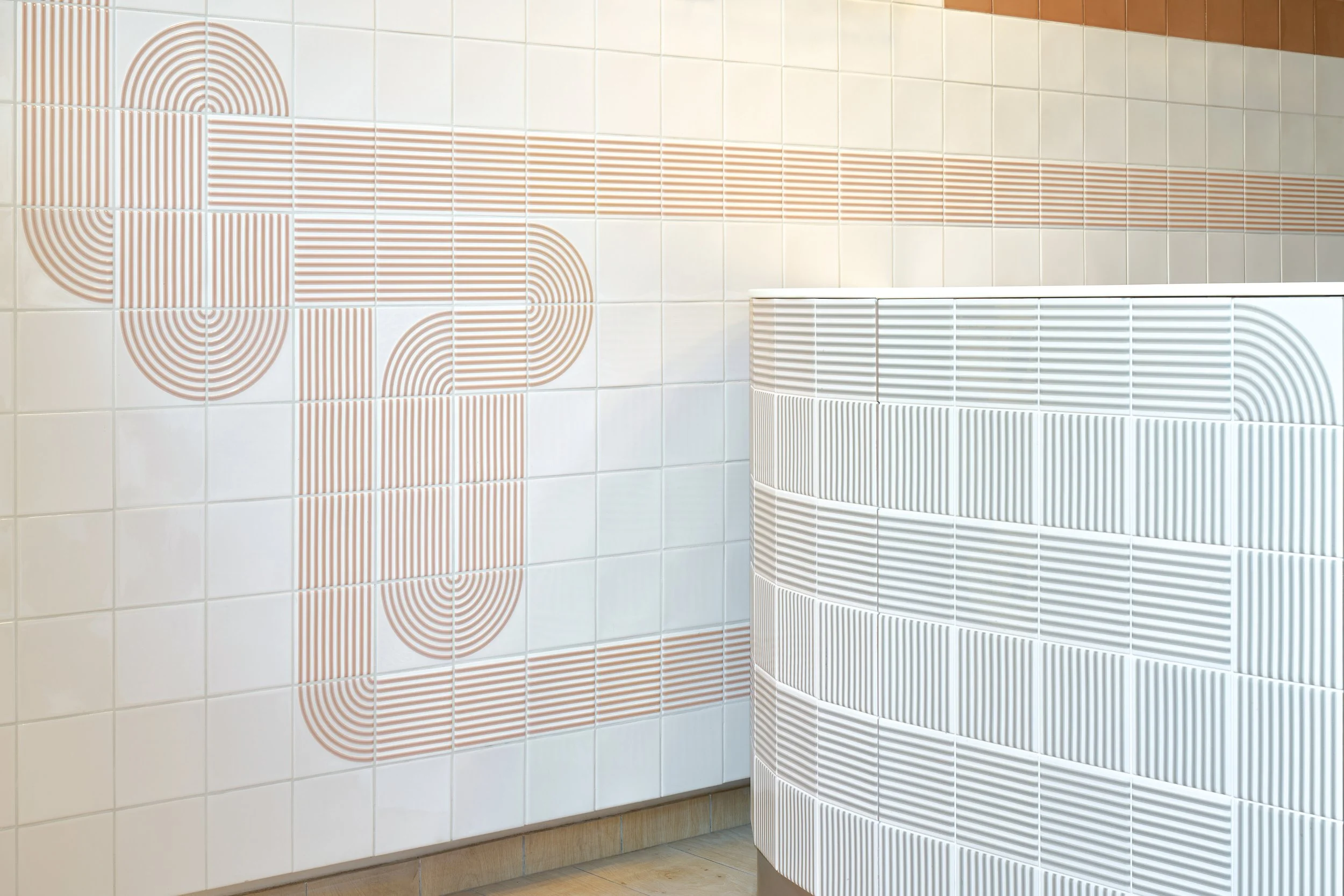 Decorative wall tiles featuring geometric patterns and a curved white radiator.