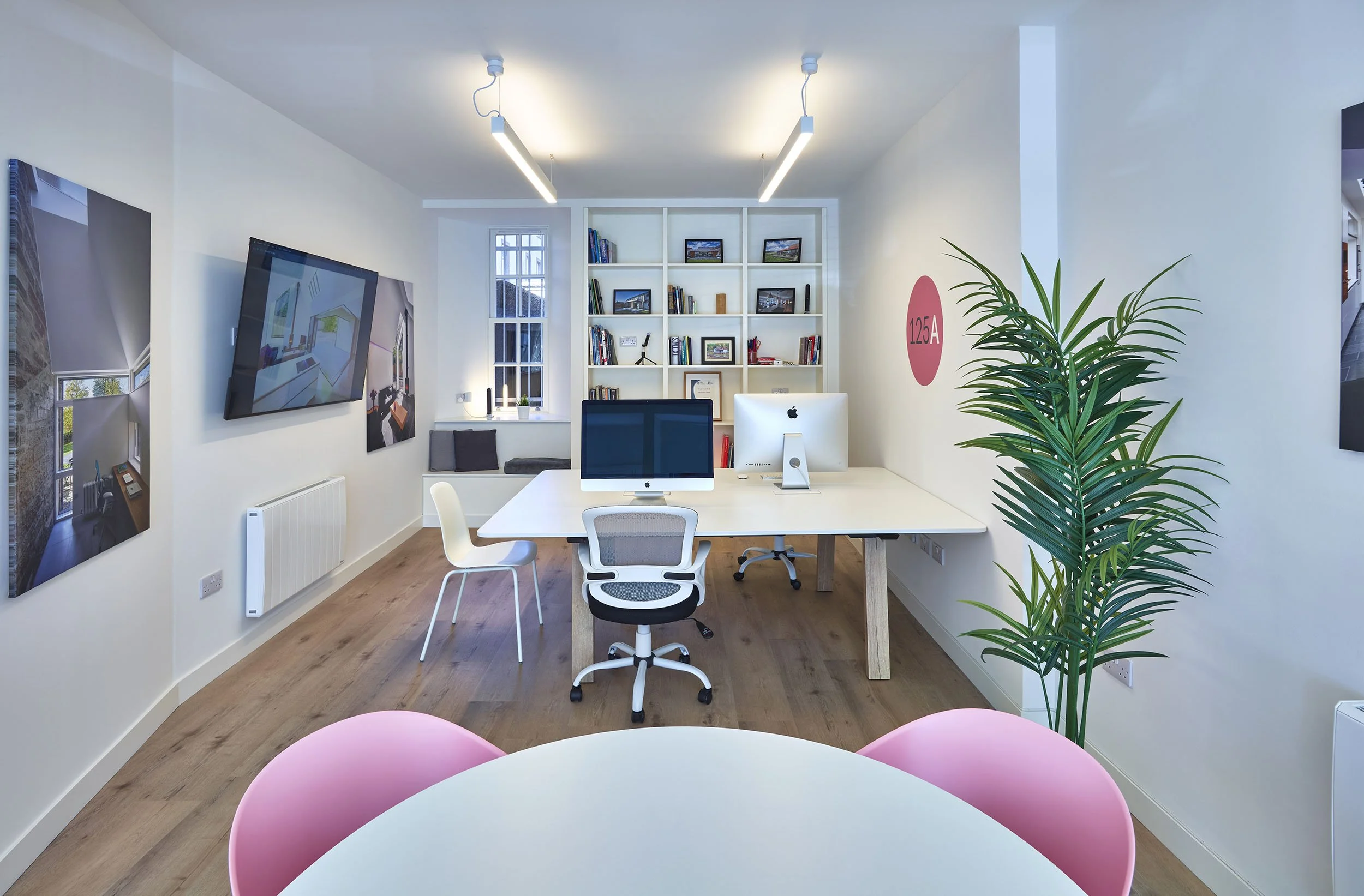 Interior of 125A Nethergate, the Dundee studio of 125Architects, with desks, computers, plants and project photographs.