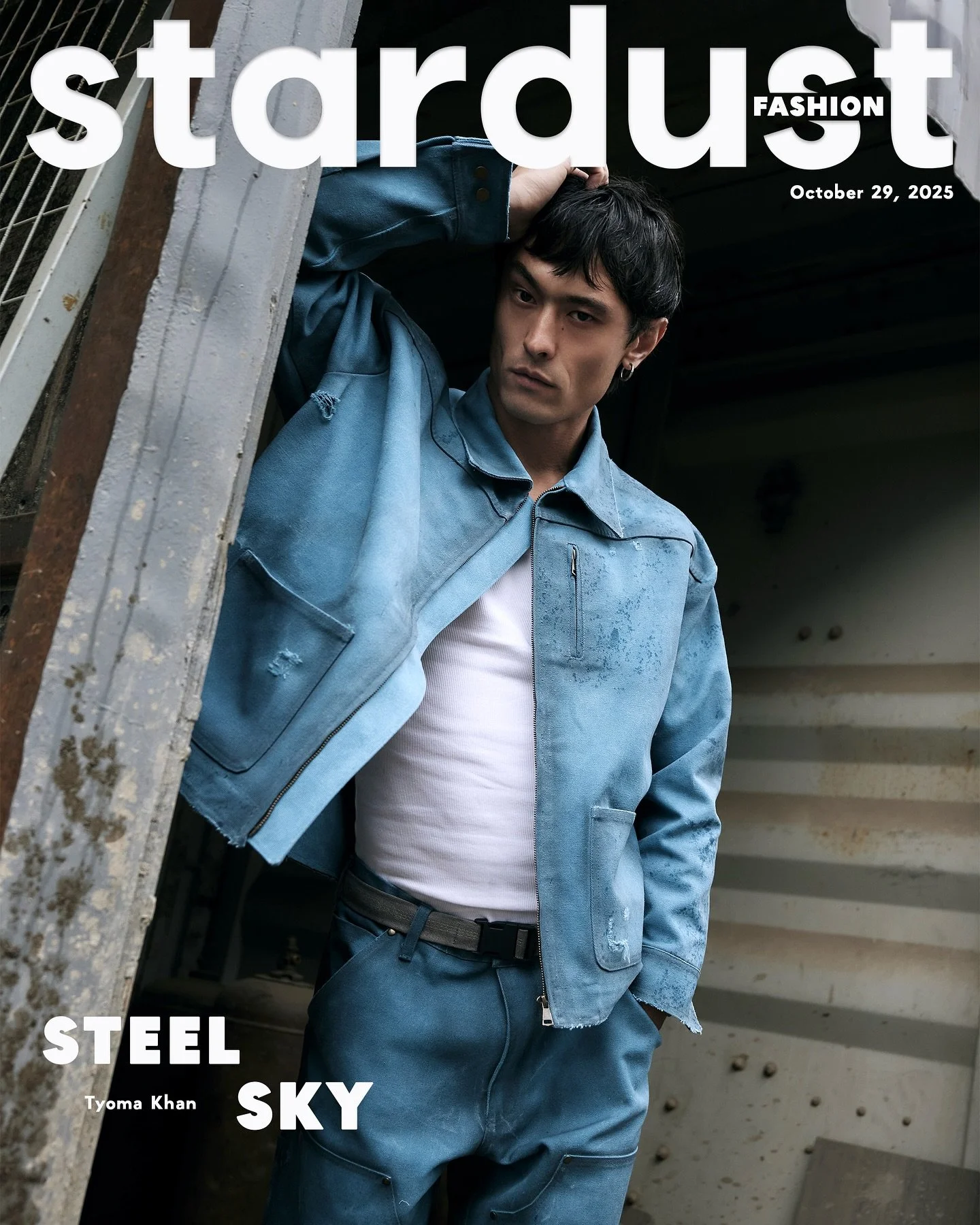 Storm light over an industrial yard. Washed and weathered workwear&mdash;frayed hems, heavy zips&mdash;set against steel and poured concrete. Utility leads the silhouette; texture carries the tone. Sky pulls wide, concrete anchors, and the scene hold