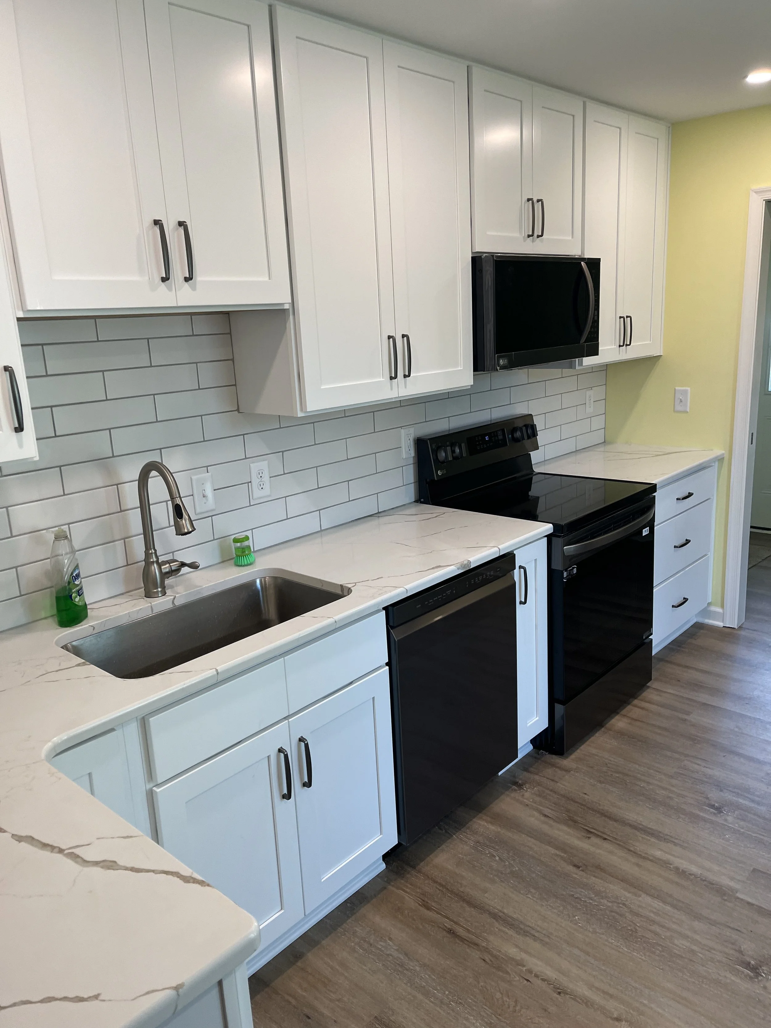 Complete kitchen remodeling with custom cabinetry, countertops, tile backsplash, and modern finishes. Residential kitchen renovation featuring new cabinets, countertops, backsplash tile, plumbing fixtures, and flooring.