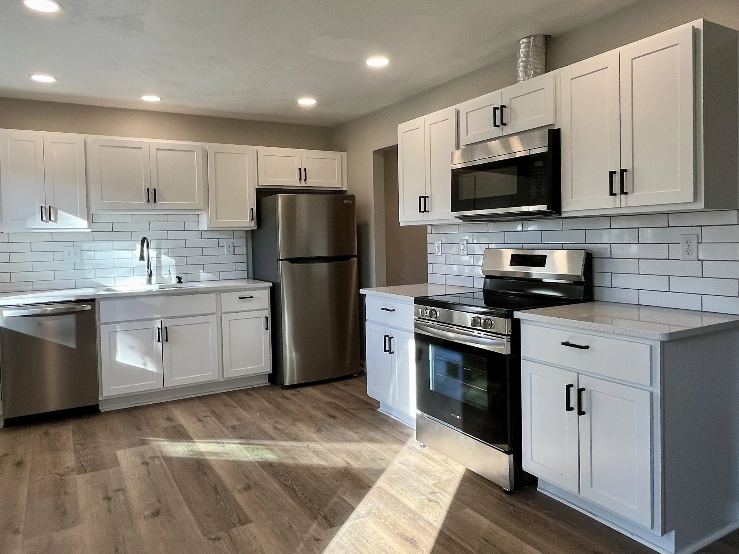Complete kitchen remodeling with custom cabinetry, countertops, tile backsplash, and modern finishes. Residential kitchen renovation featuring new cabinets, countertops, backsplash tile, plumbing fixtures, and flooring.