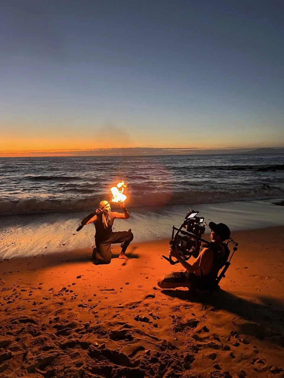Behind the Scenes of WABU Creative. Director Scott David Martin filming a fire performer on the beach at sunset in Puerto Vallarta, Mexico. 