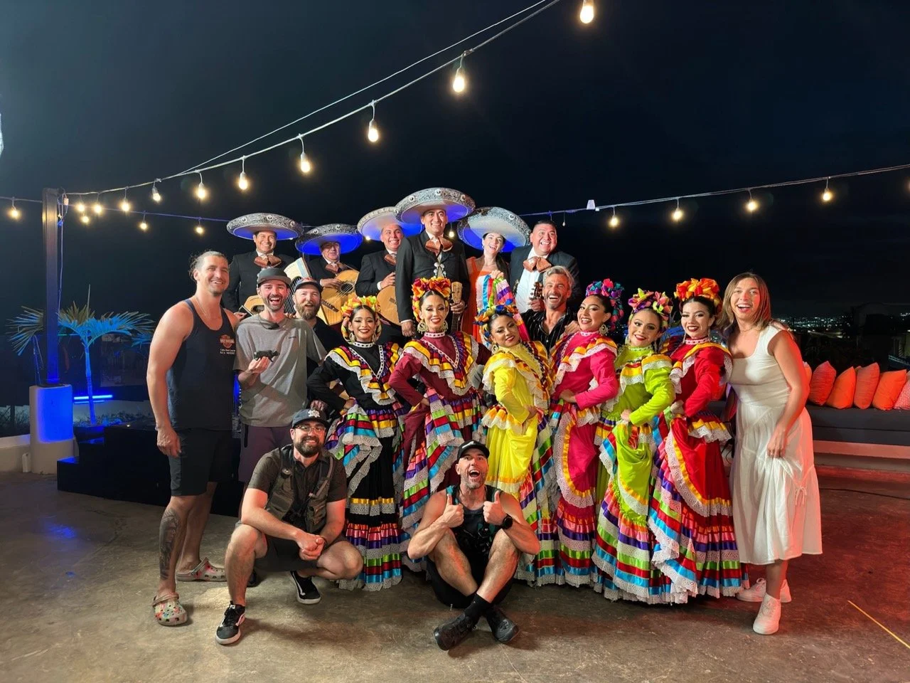 Behind the Scenes of WABU Creative. Wrapping our Cabo San Lucas production with talent dressed in colorful traditional Mexican folkloric dresses and sombreros, with string lights overhead.