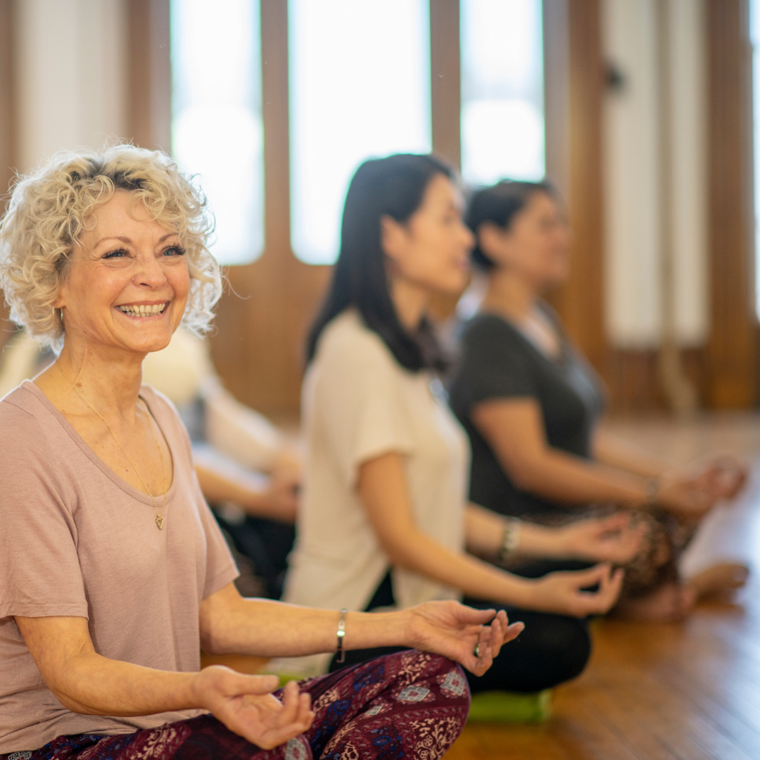 Event or course; group of women, cross legged, hands on knee, smiling