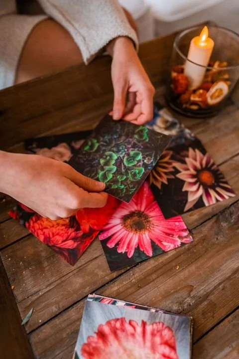 woman holding custom fine art postcard above wood table