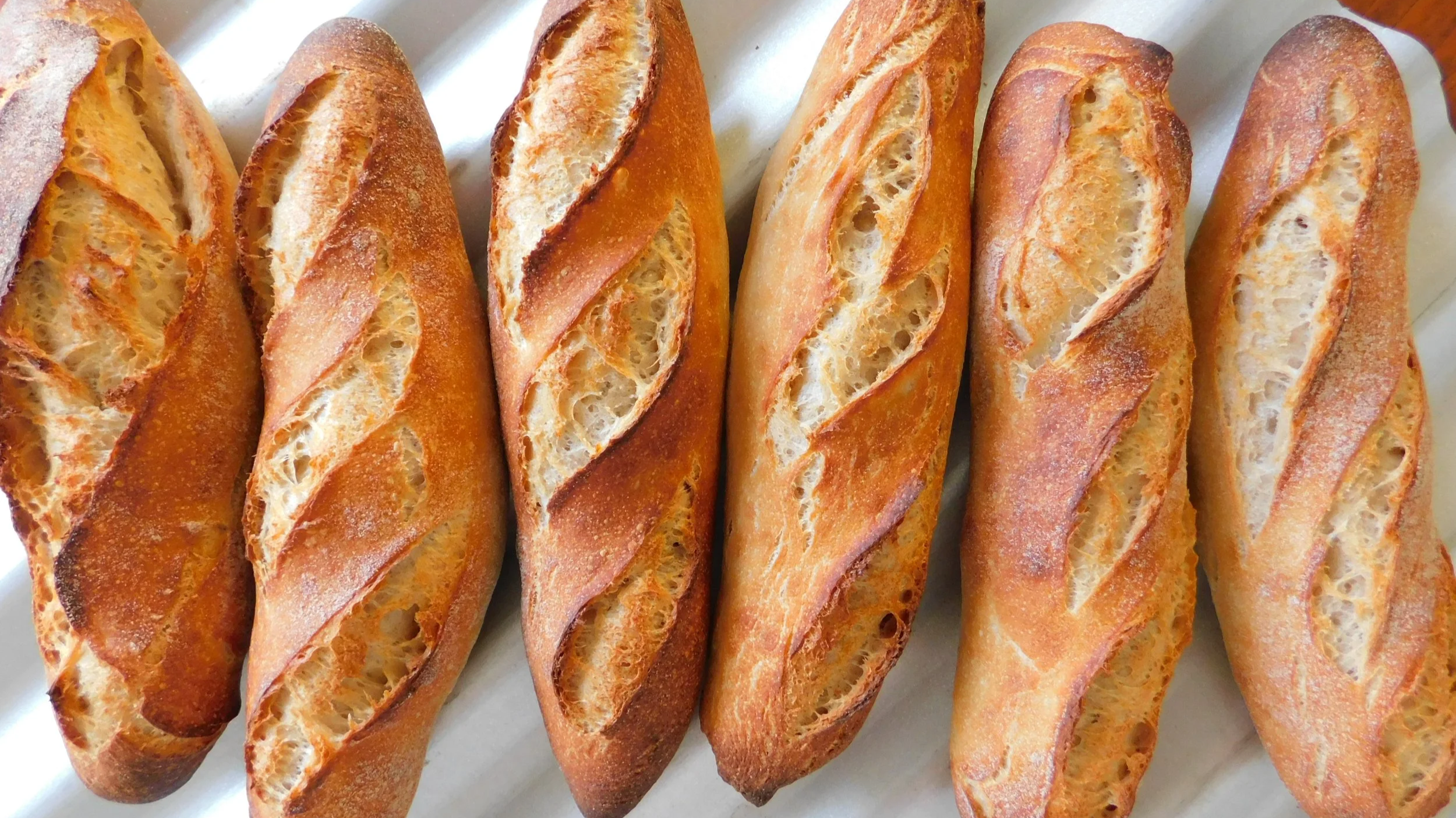 freshly baked demi-baguettes cooling from the oven