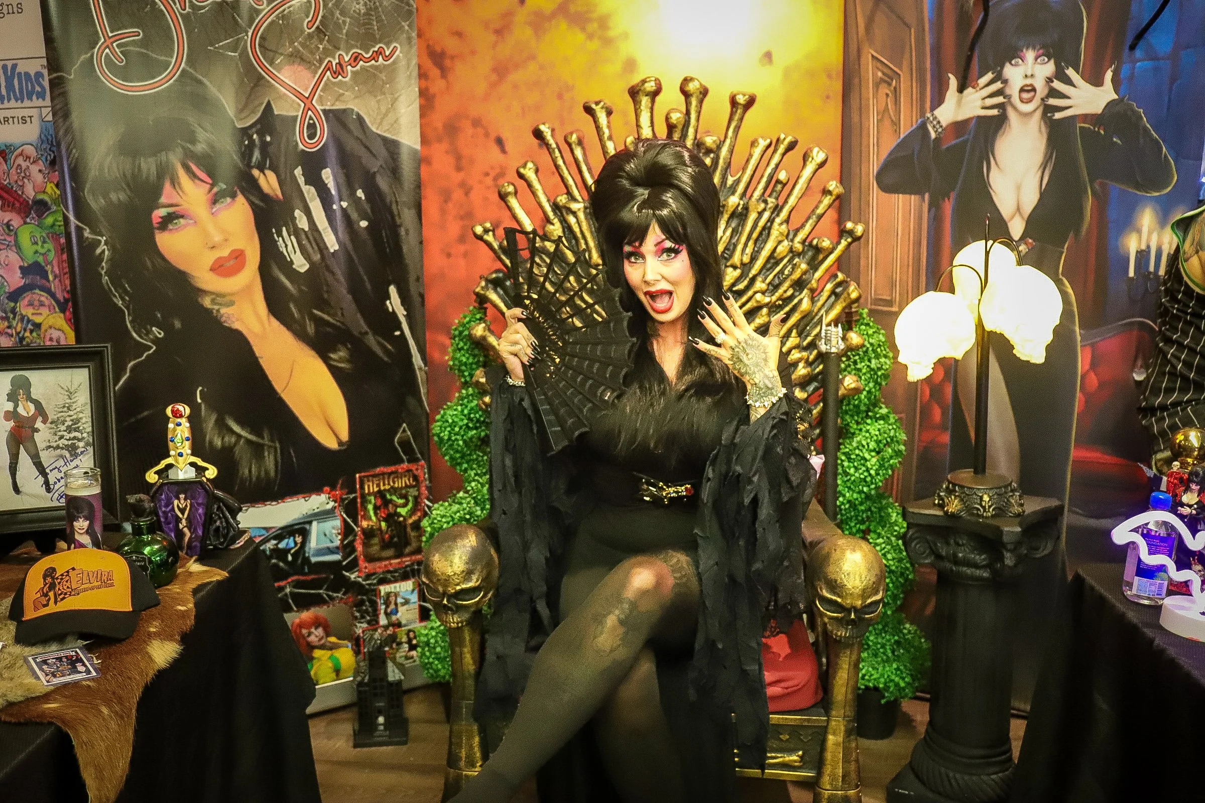 Cosplay participant dressed as snow white standing in front of a sign that says "Once upon a time. A castle cut out is behind her and a table with storybook trinkets is next to her.