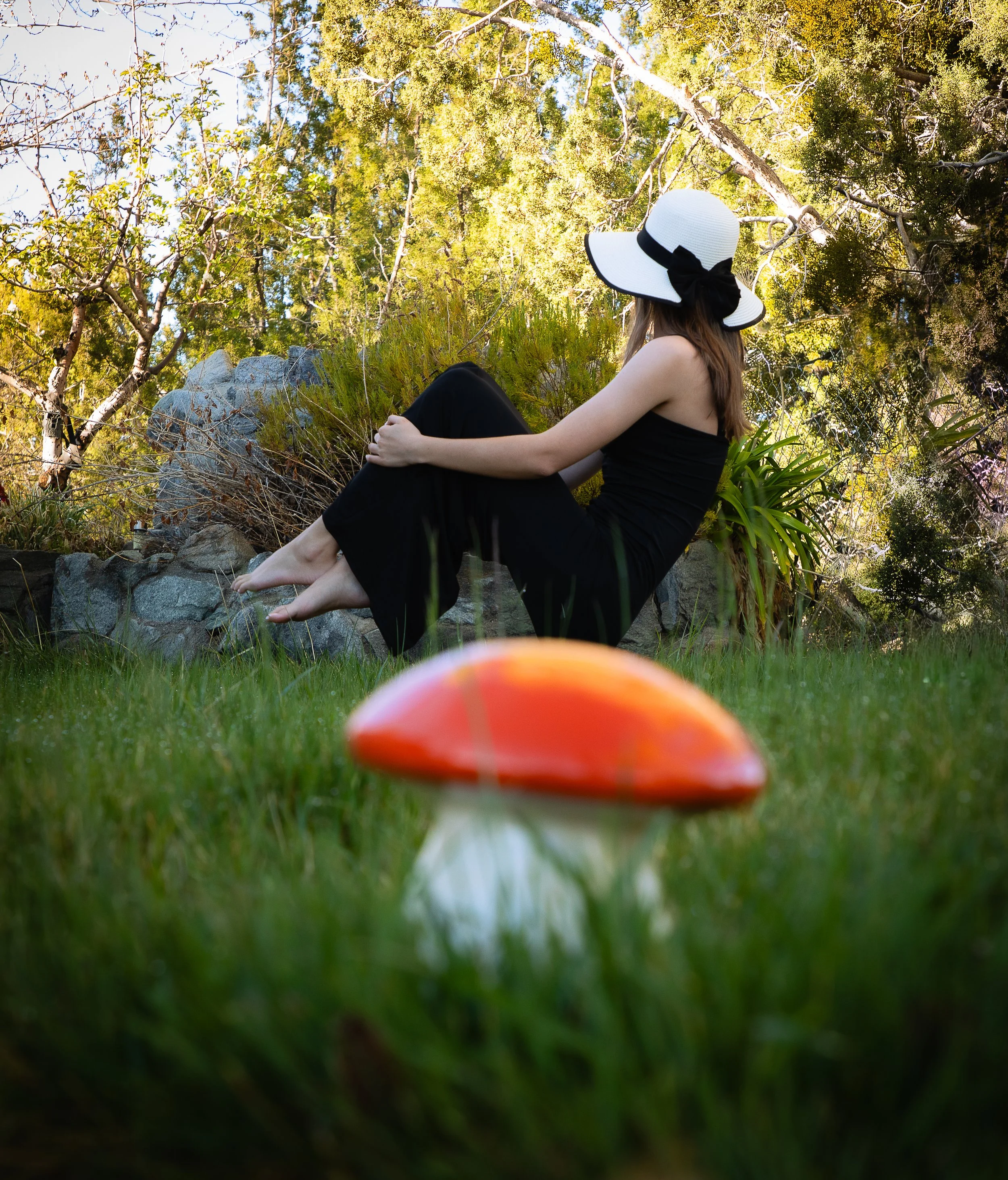 Lady sitting on a mushroom in a park in the high desert by family photographer.