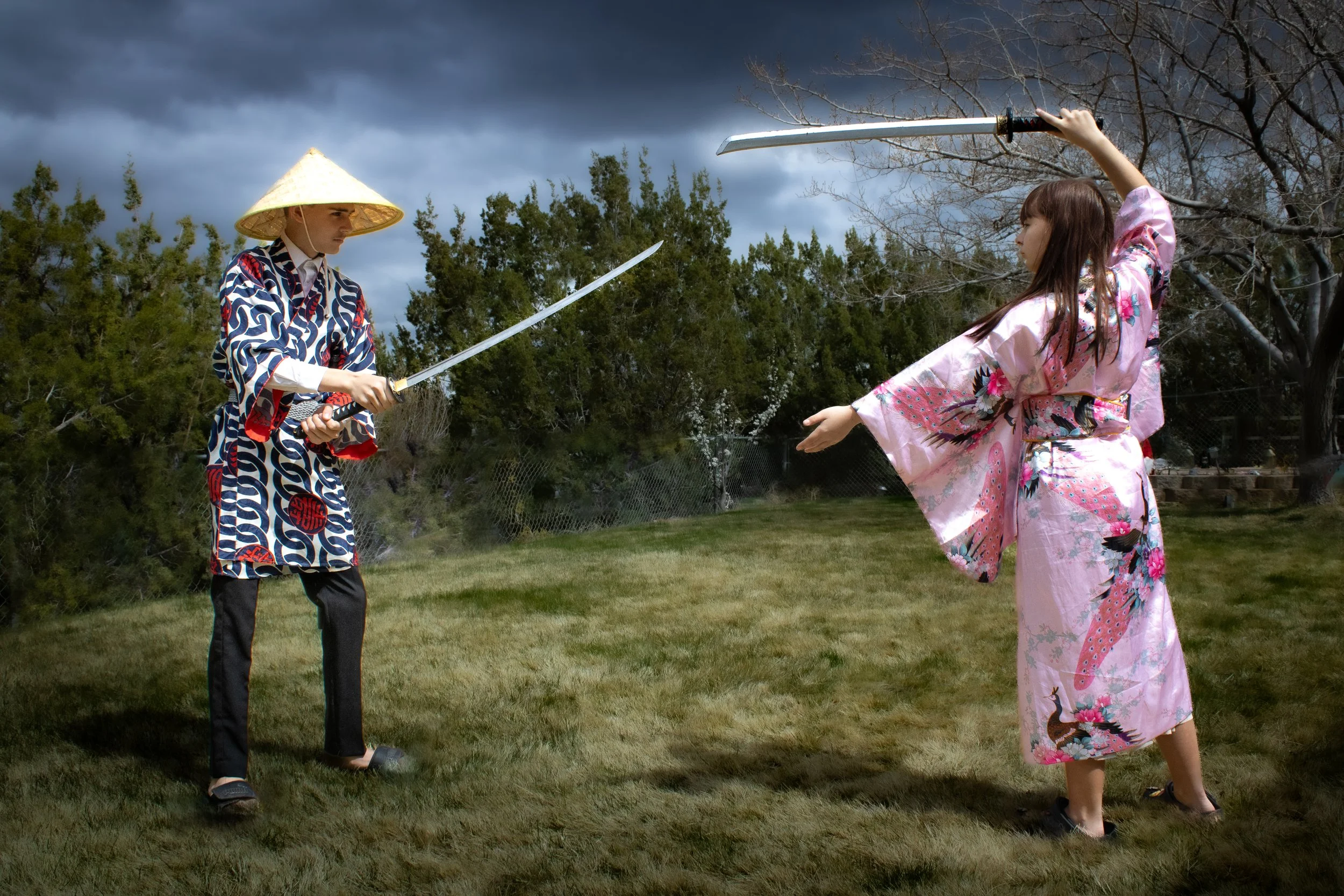 High desert kids photography for big and little ones. Image shows 2 big children playing dress up and pretending to sword fight.