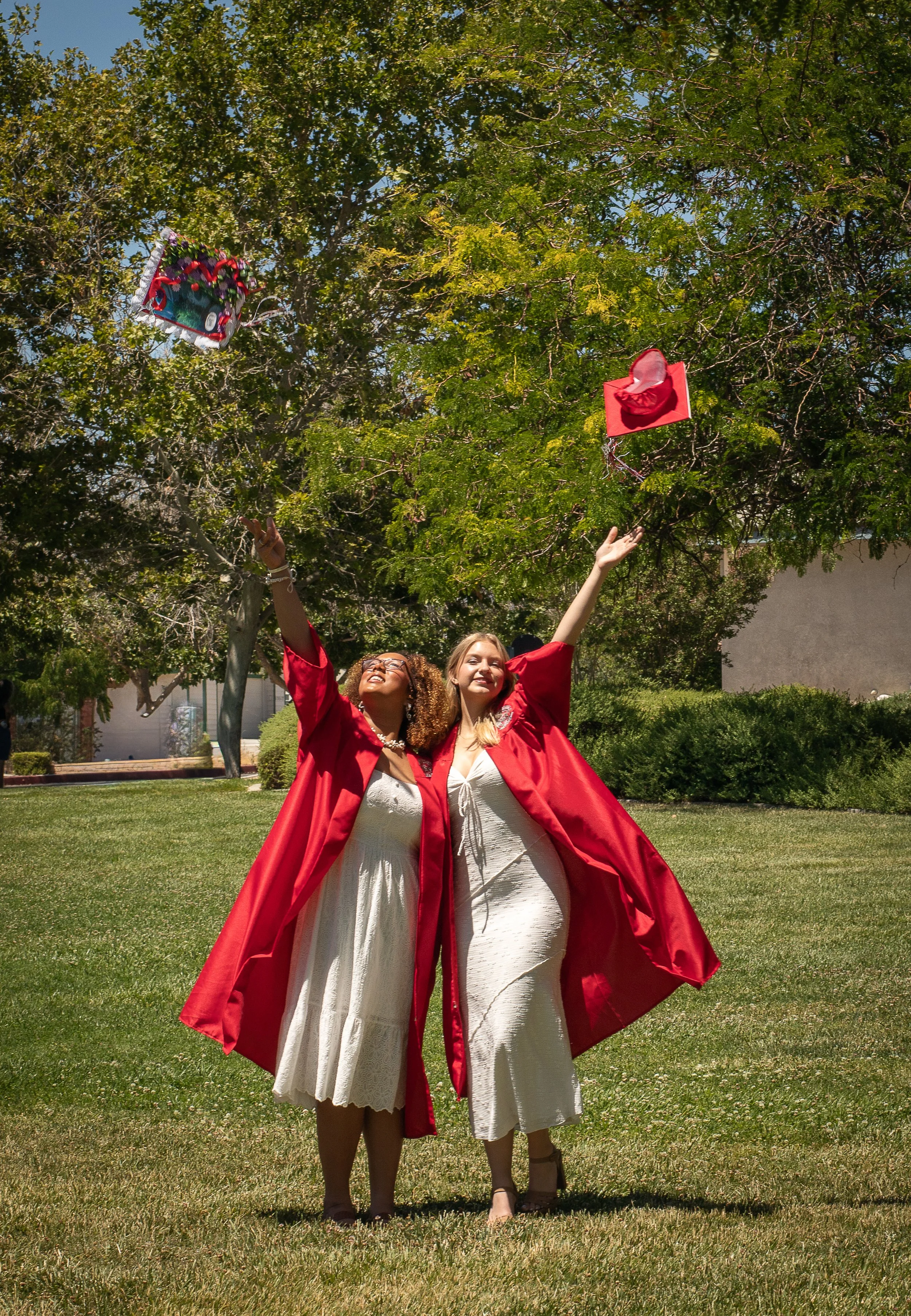 Friends throwing caps in the air after graduation. High desert fantasy photographer.