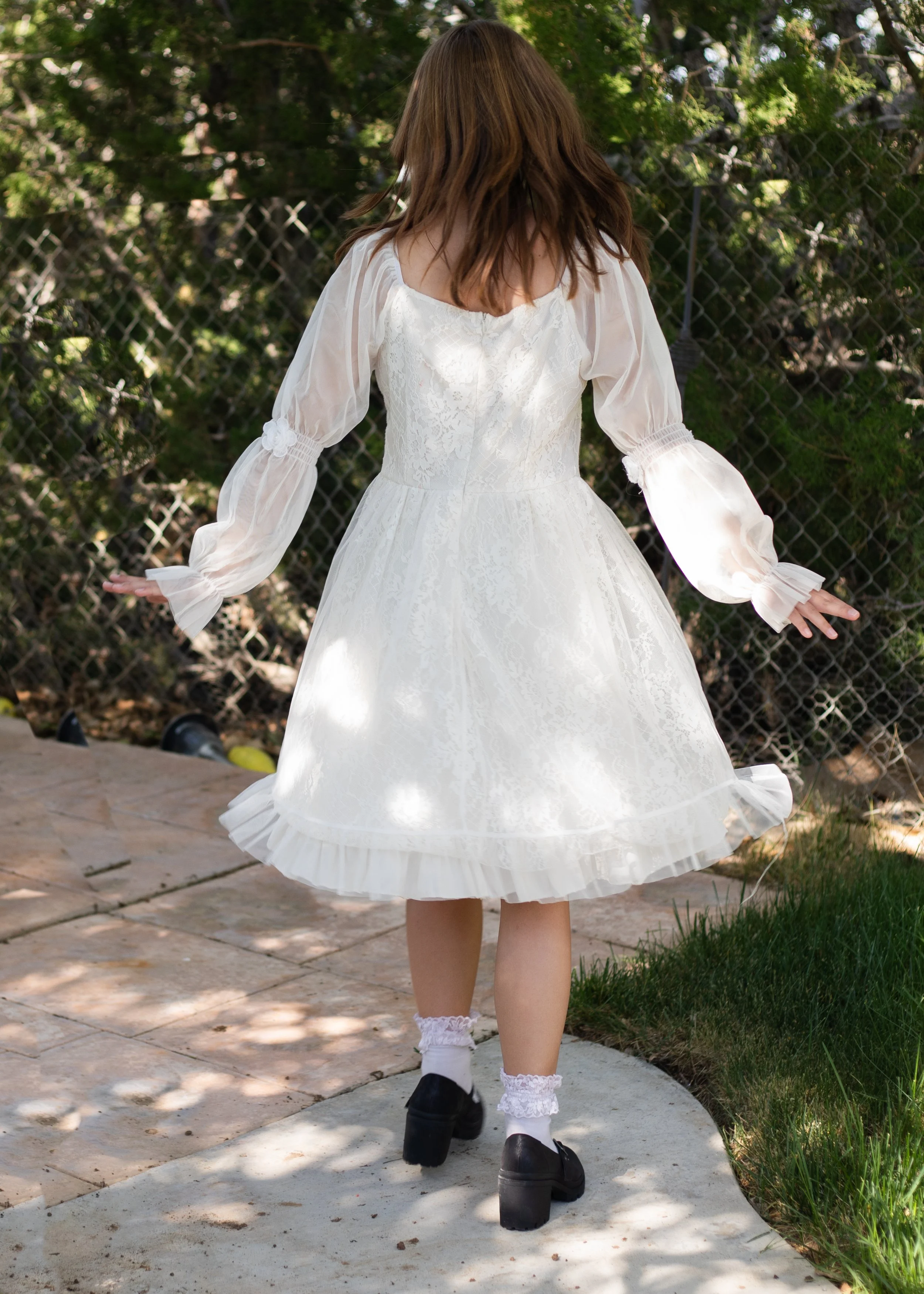 young girl dancing in white dress by family photographer in phelan california.