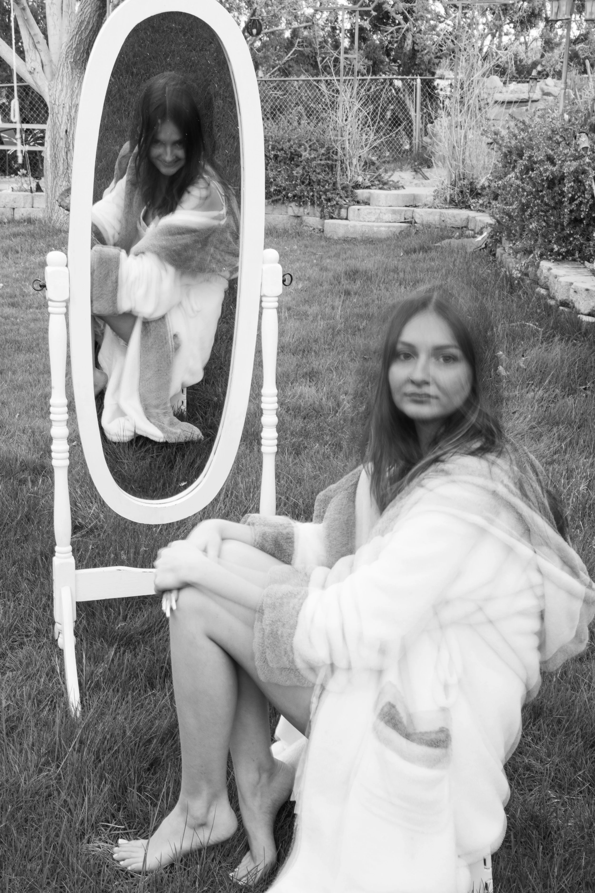 ghost looking back at woman from the mirror while woman looks at camera