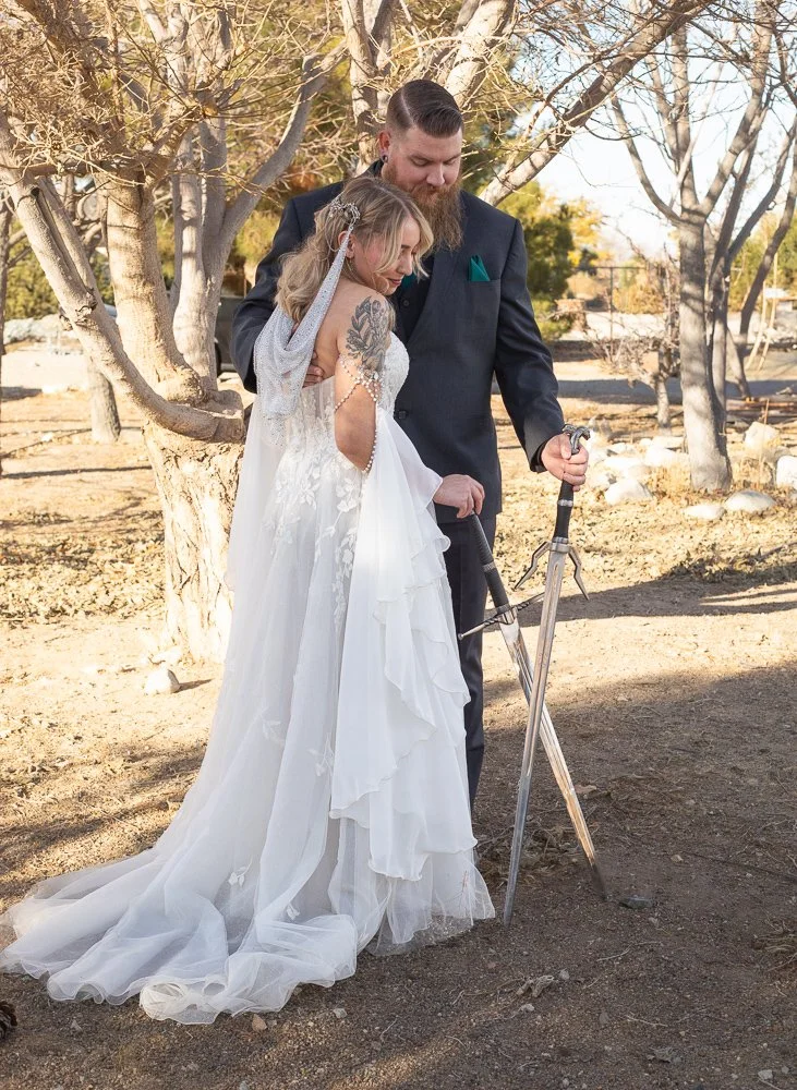 Whimsical wedding photographer in the high desert. Bride and groom outdoor photos holding swords.