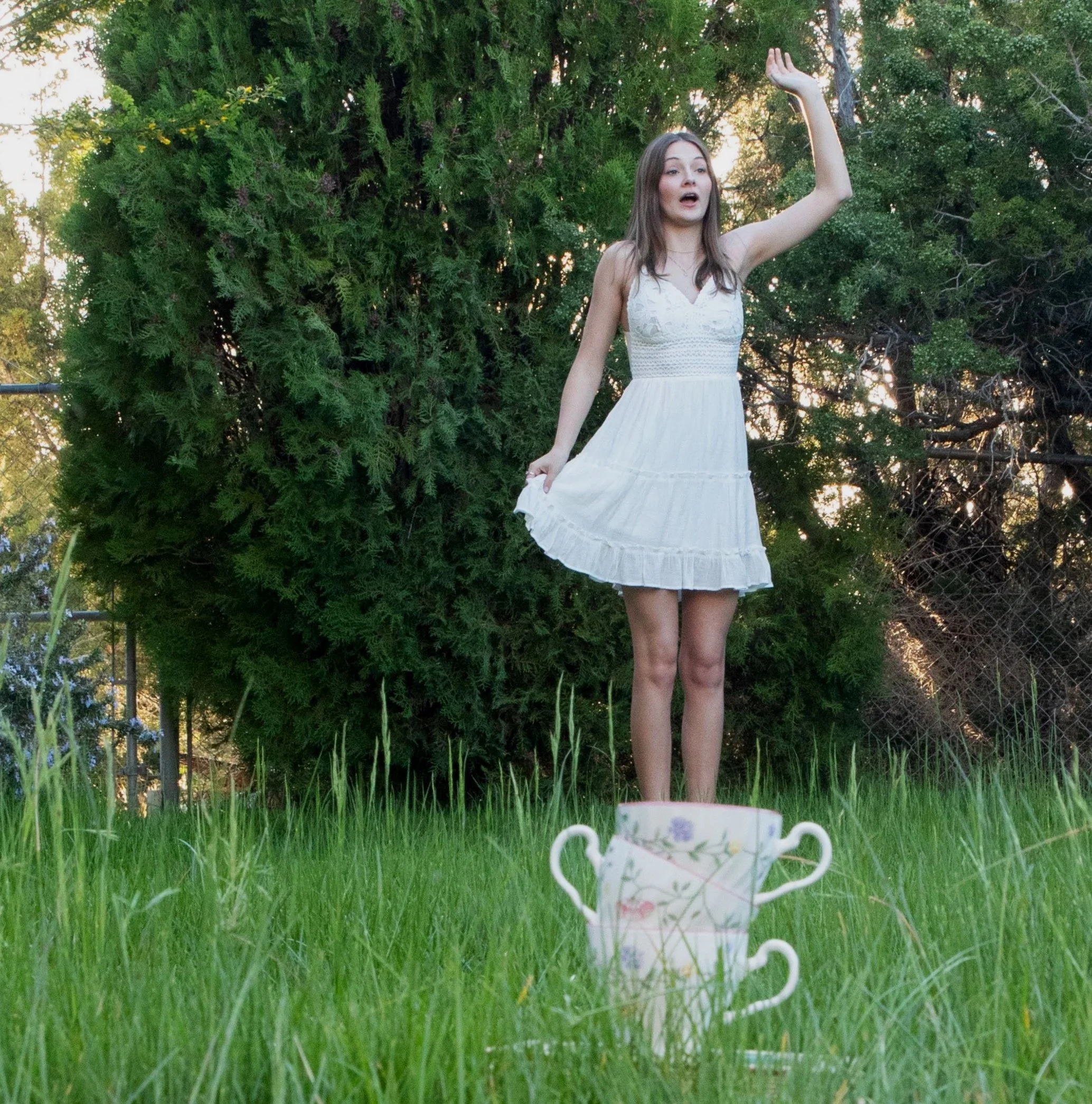 Girl jumping into stack of teacups by fantasy photographer annette marie in the inland empire, ca.
