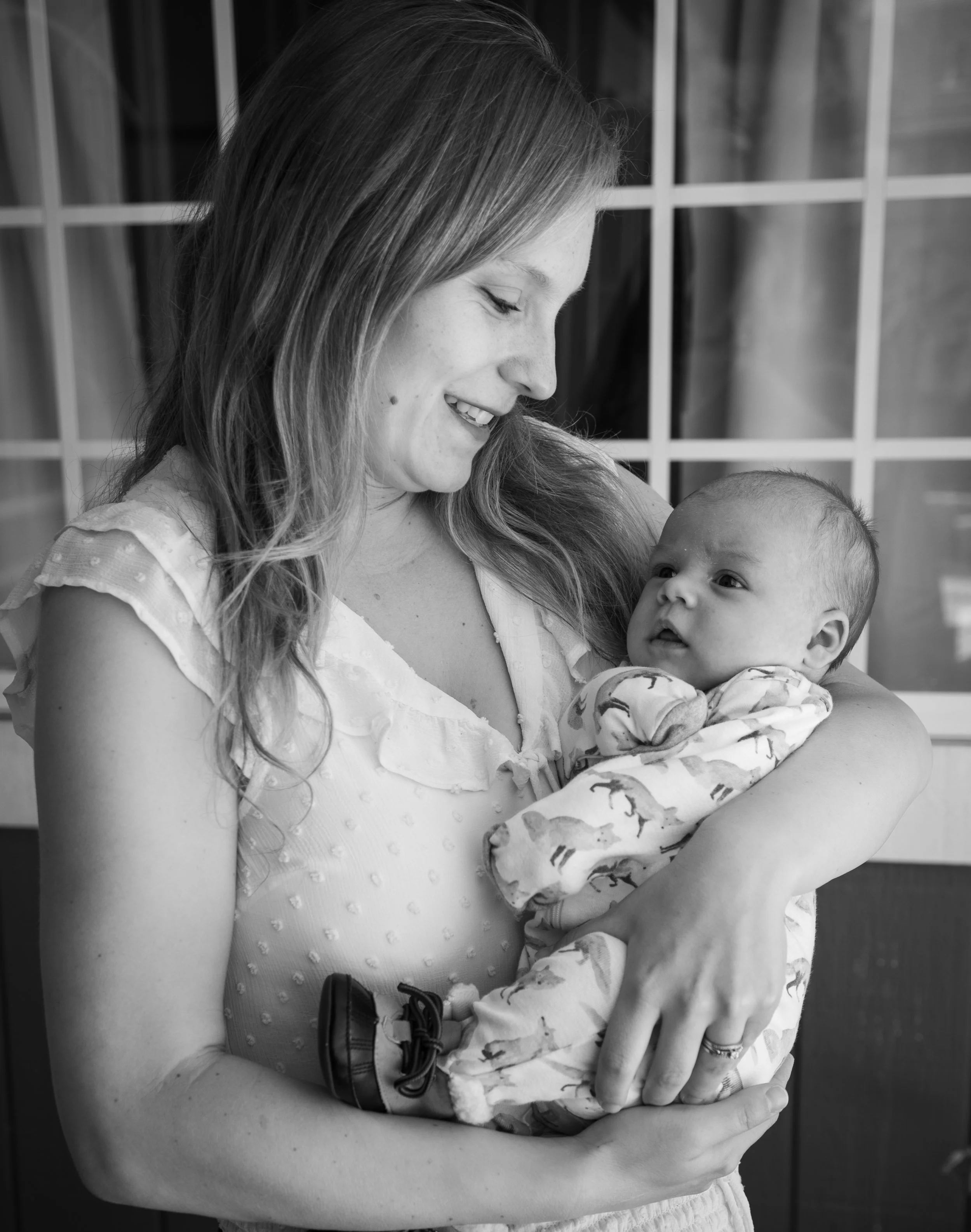 Mom looking at nerbown baby in inland empire by photographer.