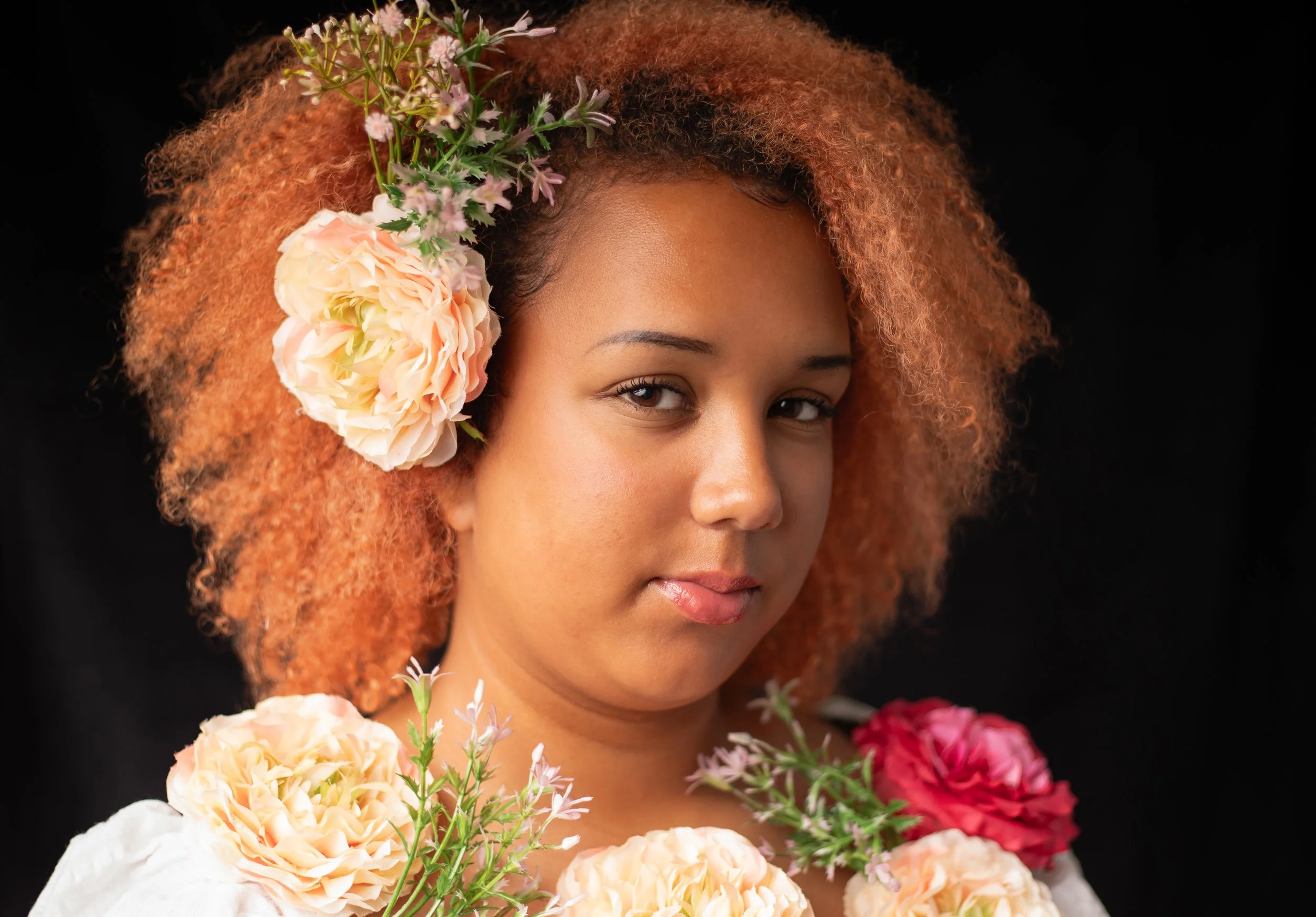 young black girl with large flowers in her hair, by southern california fantasy photographer.