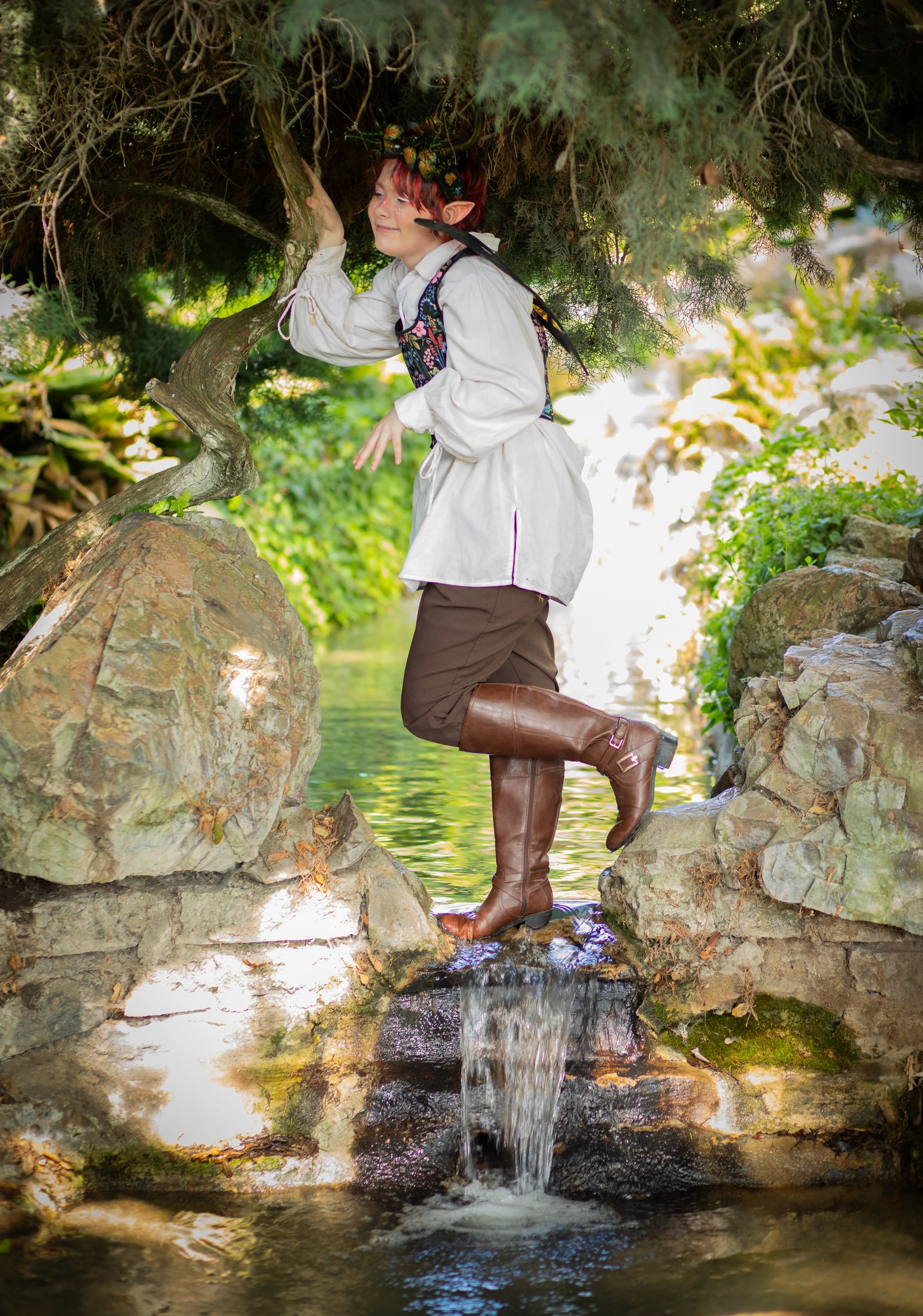 Teen dressed as woodland fairy with ears and wings, standing next to a waterfall. California, high desert photographer for fantasy and whimsy portraits.