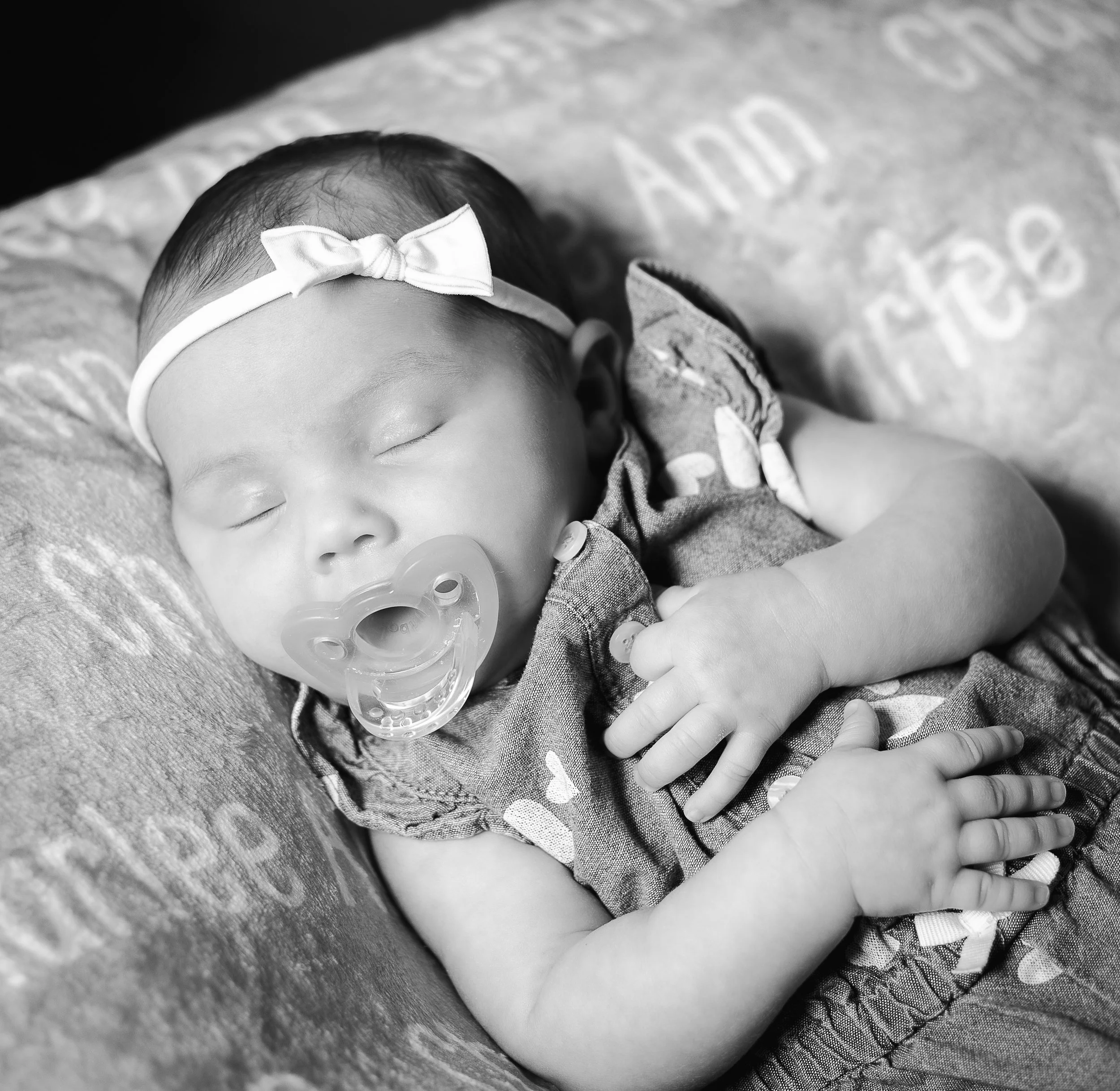 Newborn baby girl asleep with pacifier by high desert family photographer.