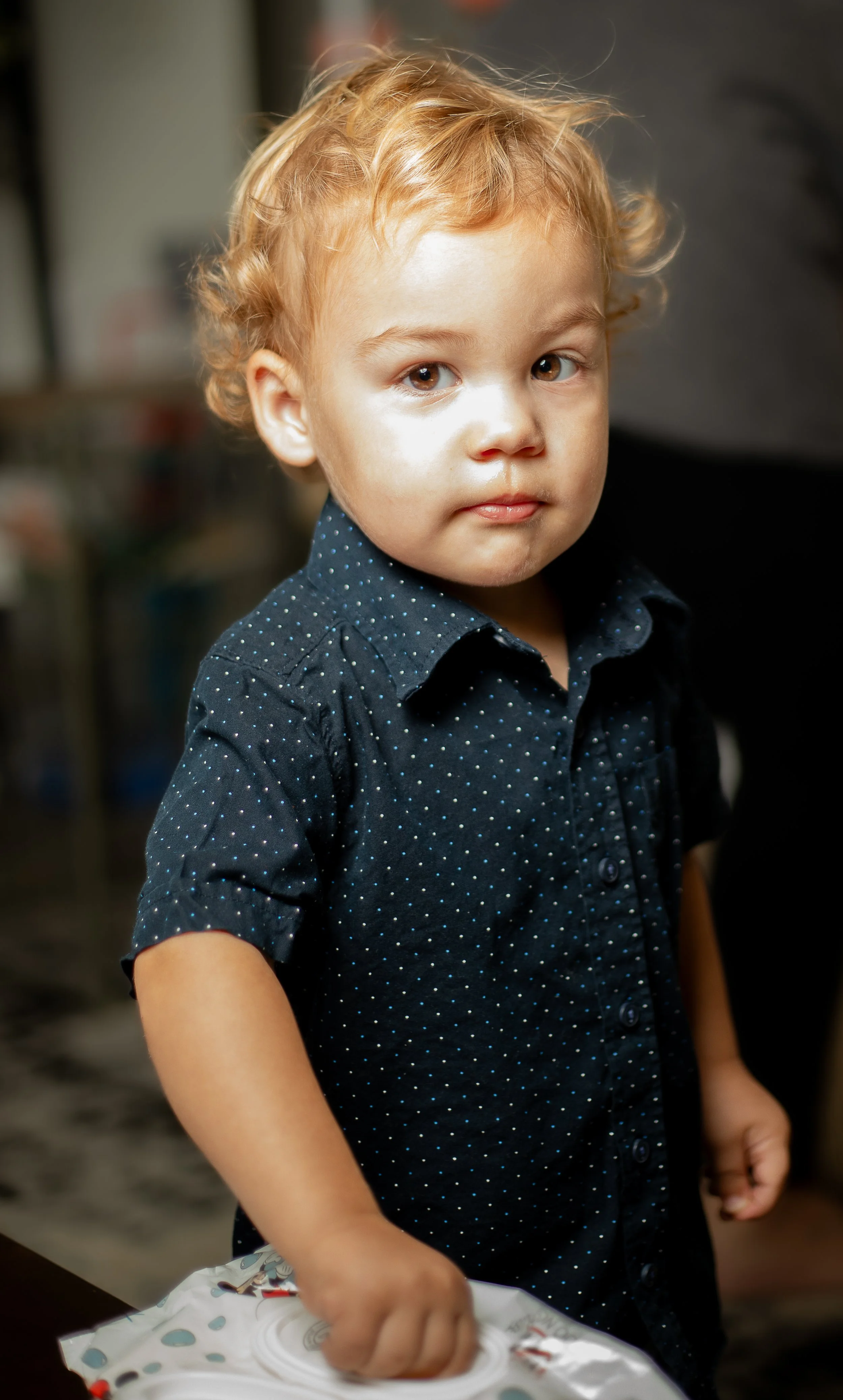Toddle boy looking at camera and grabbing wipes out of the box. what to expect in a toddler photo session by hesperia family photographer.