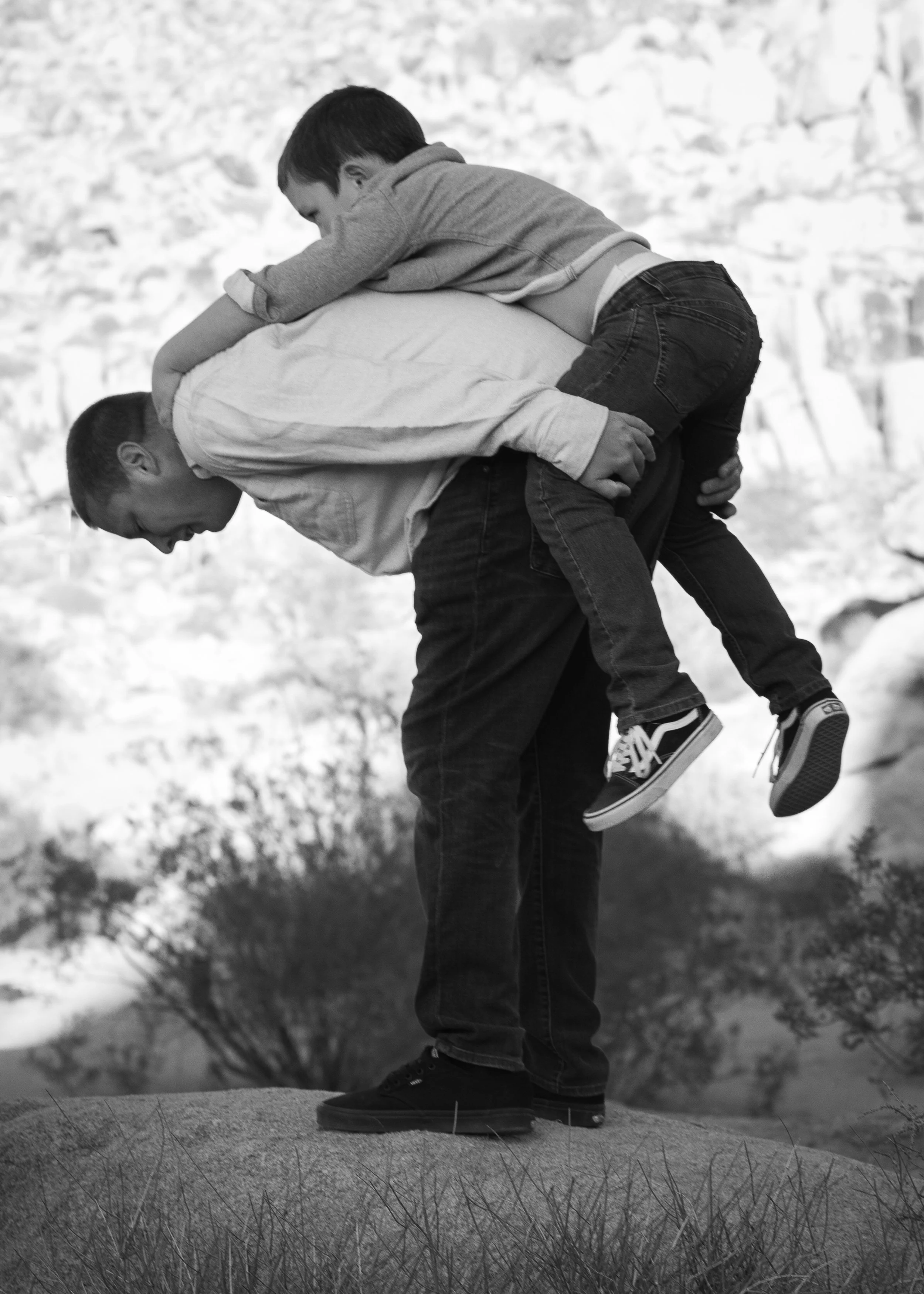 dad giving son a piggy back ride in the desert by high desert photographer for families.