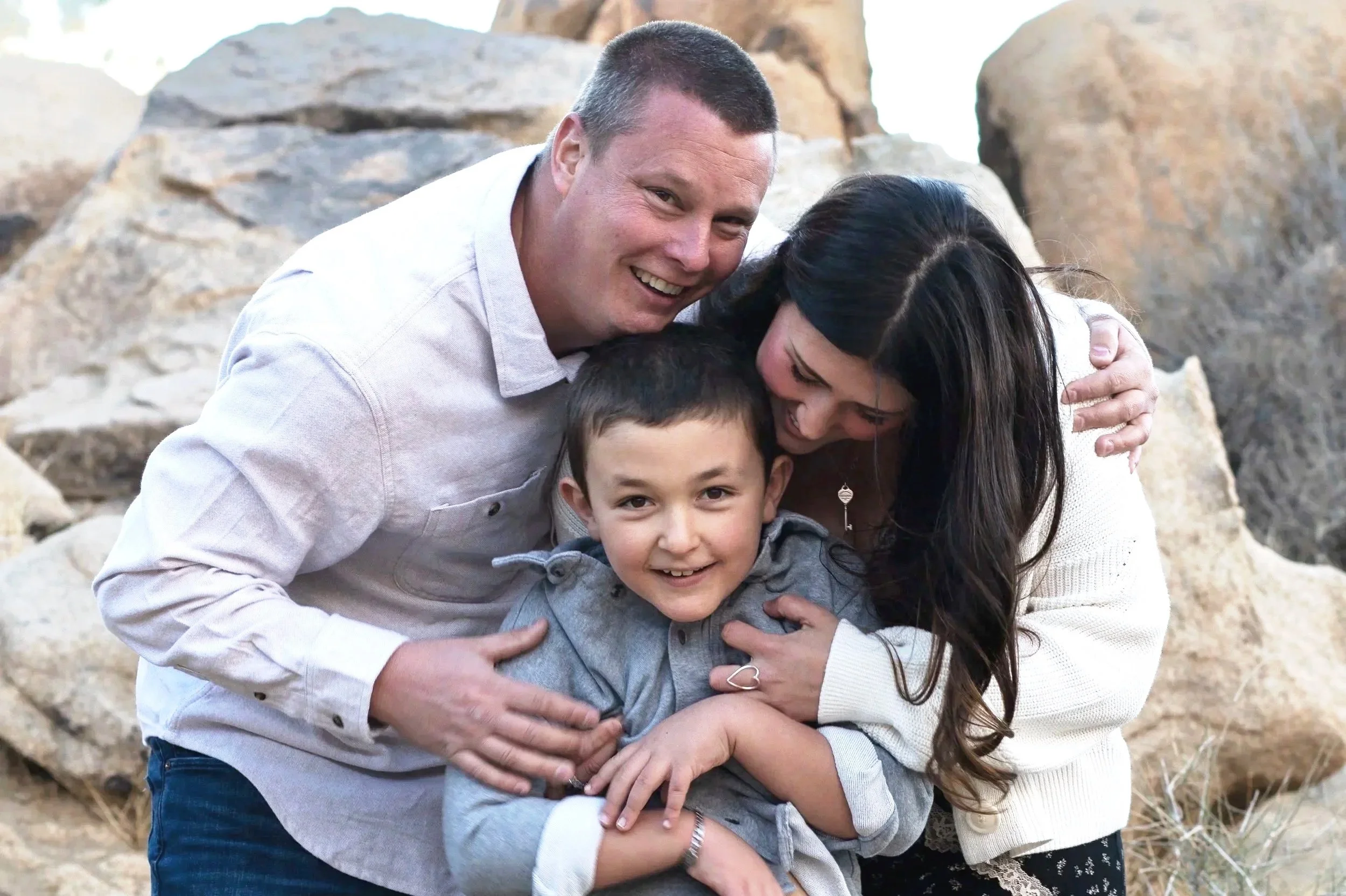family of three photo outdoor in front of large rocks. Family photographer in apple valley, ca.