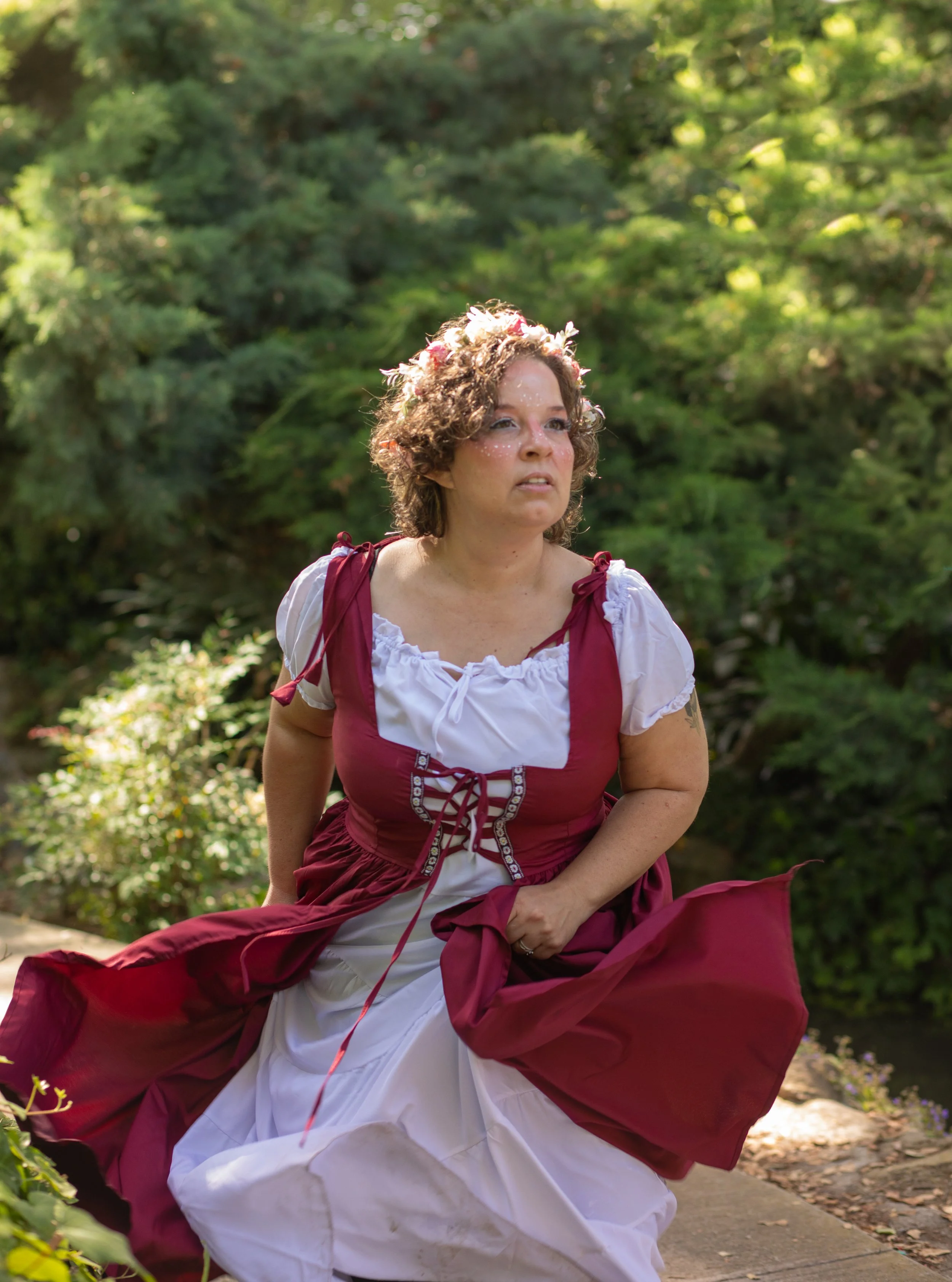 Woman dressed in renaissance clothes running, holding her dress, wearing flower crown by high desert, california fantasy photographer.
