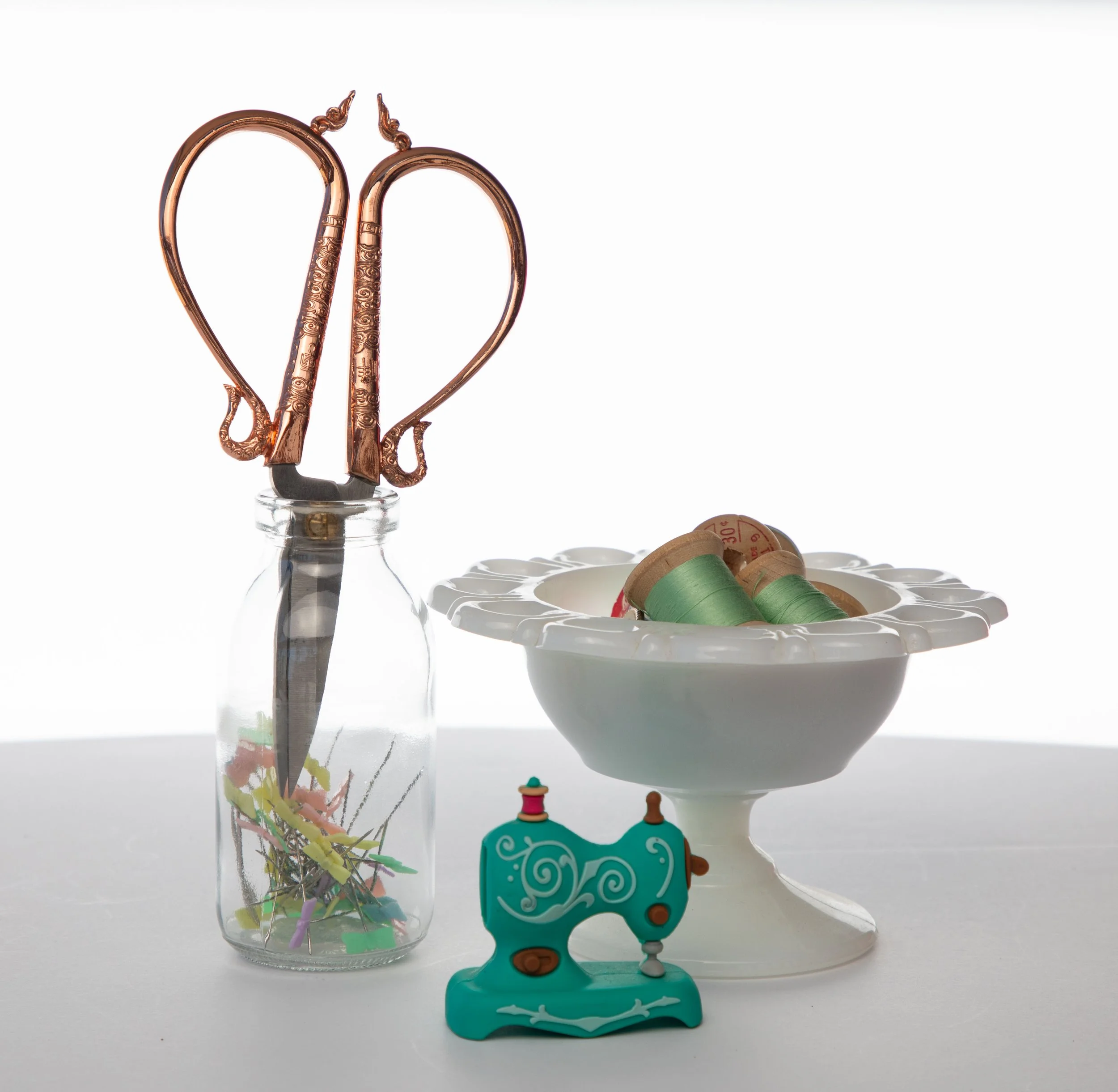 Sewing notions are scissors, pins, thread, and a tiny jar by high desert photographer.